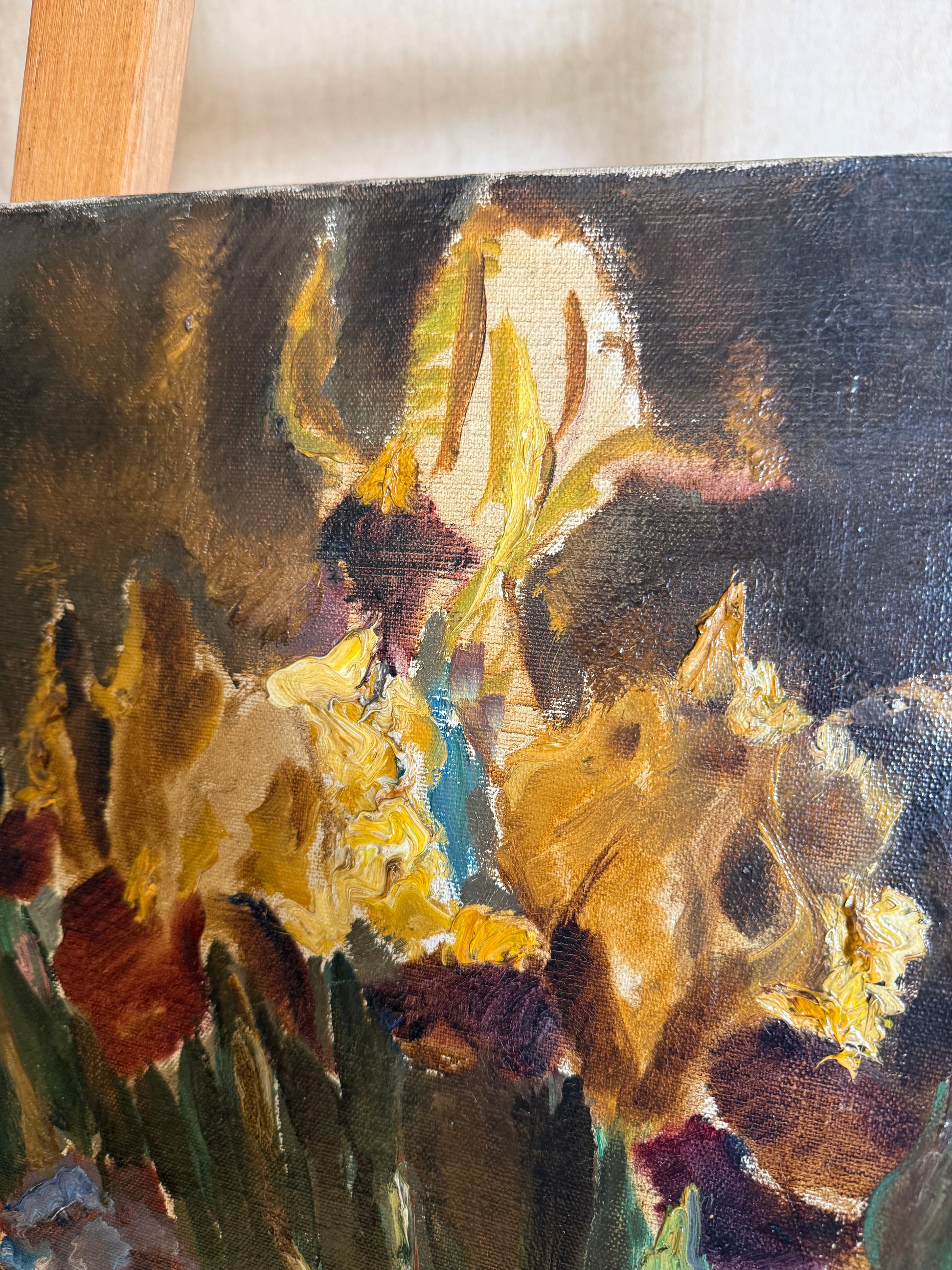 Close-up of an oil painting depicting yellow and white irises with thick impasto brushstrokes in dark brown, green, and gold tones.