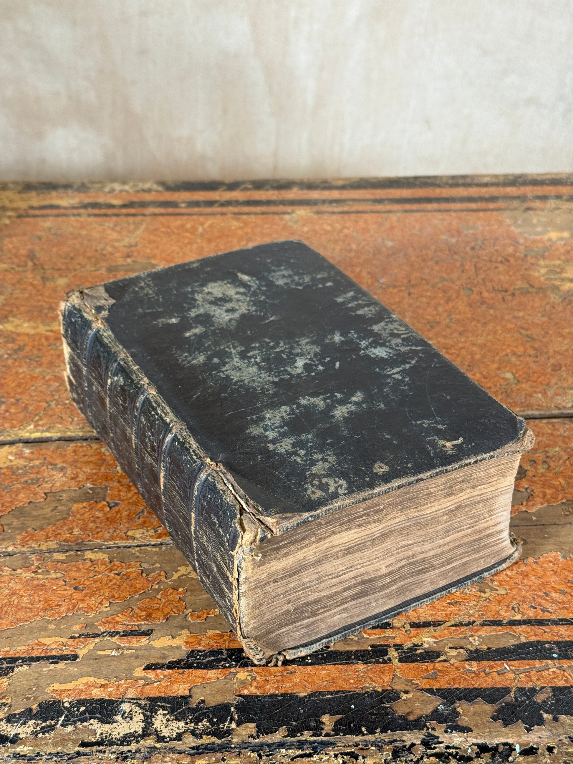 Vintage book with worn leather cover on a textured surface