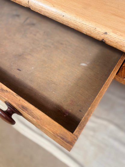 Close-up of an open wooden drawer showing the interior wood grain and a dark brown drawer pull knob.