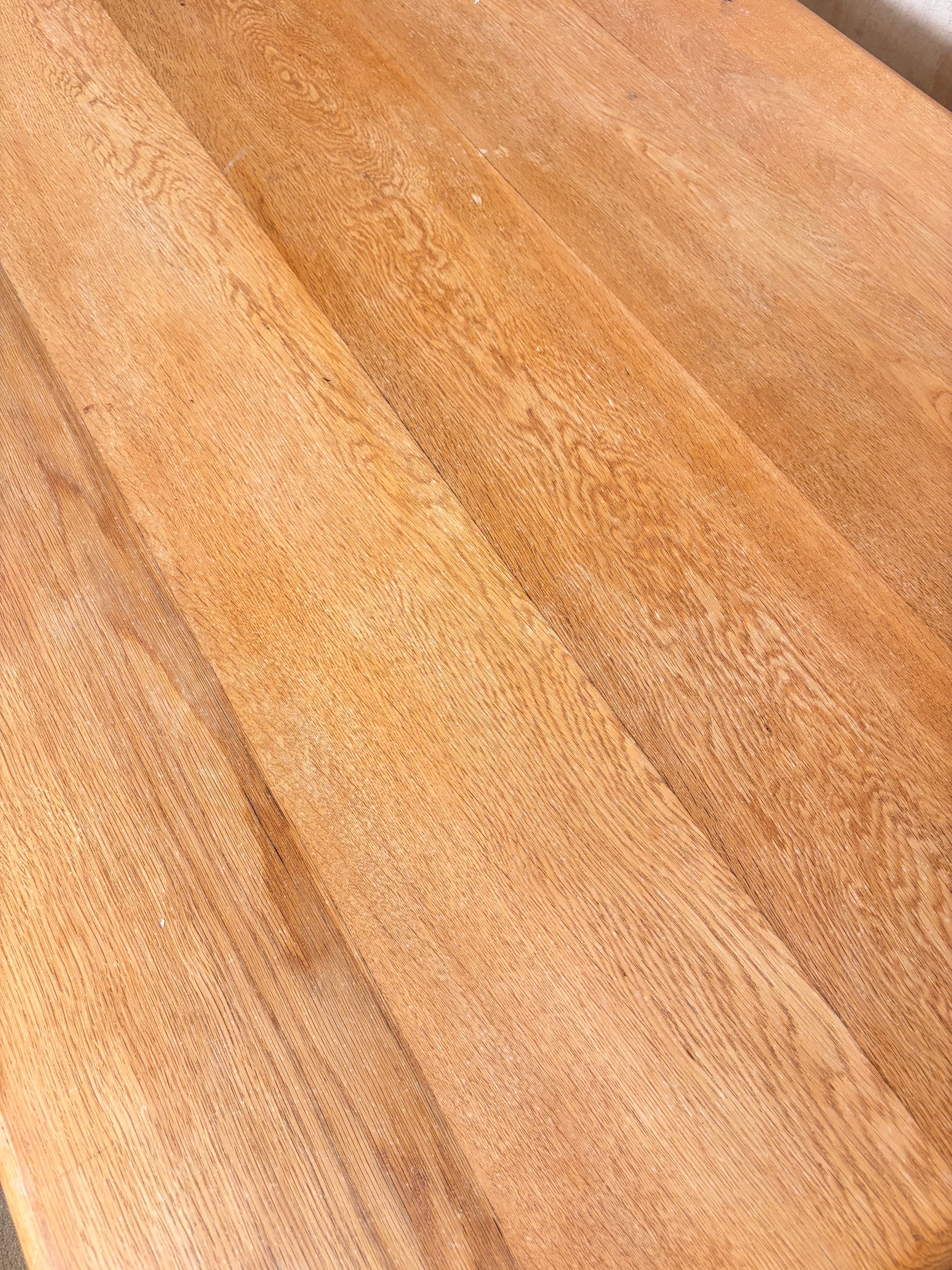 Close-up of a light brown wood surface with visible grain and plank seams.