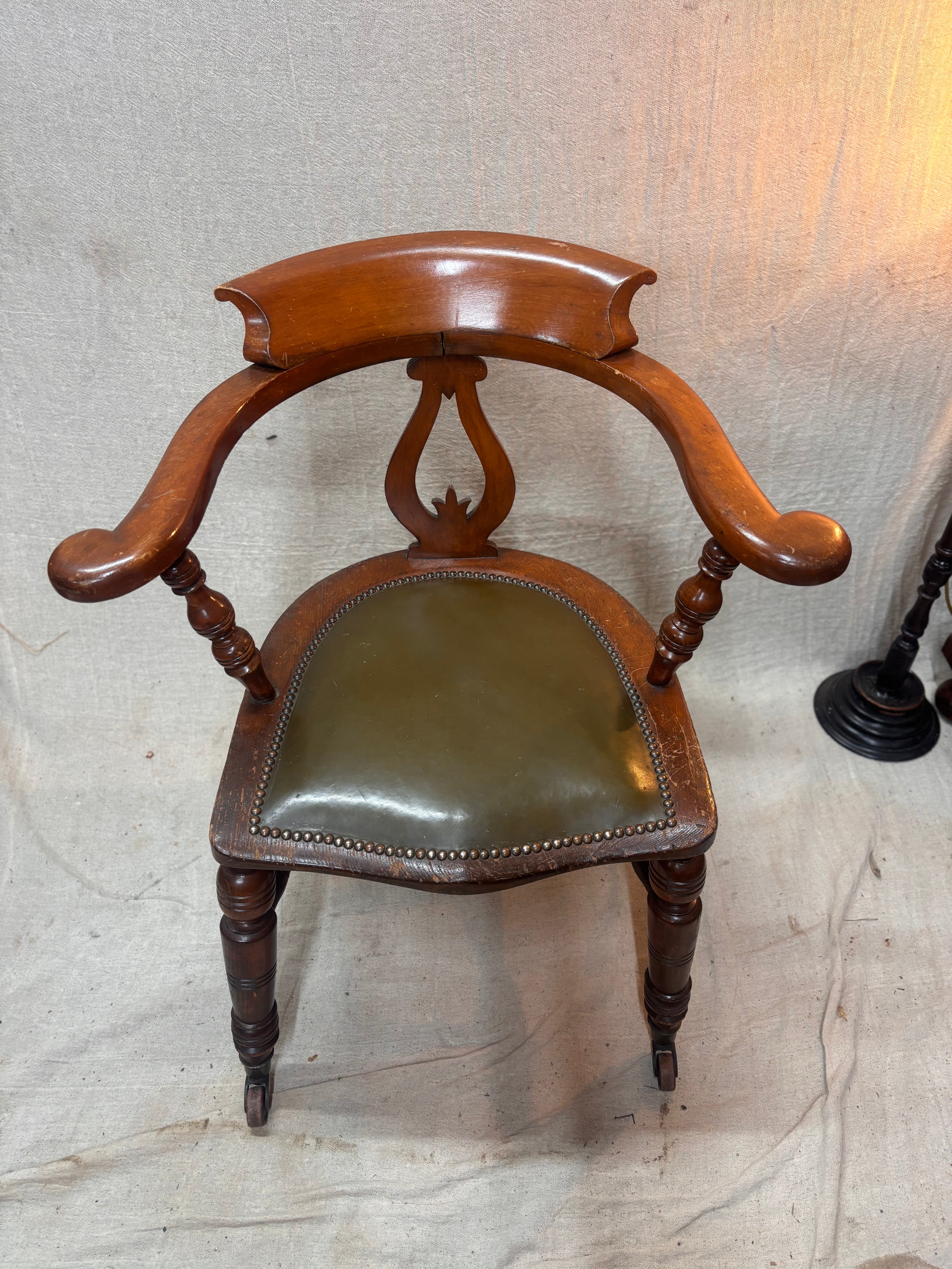 A green leather wooden chair against a plain background