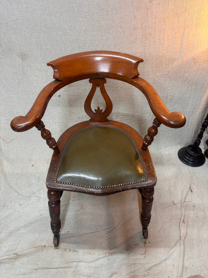 A green leather wooden chair against a plain background