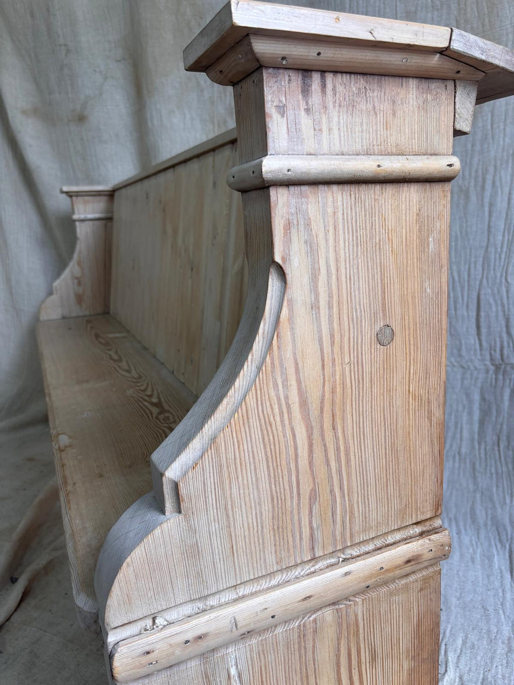 Wooden bench with a textured surface against a plain background