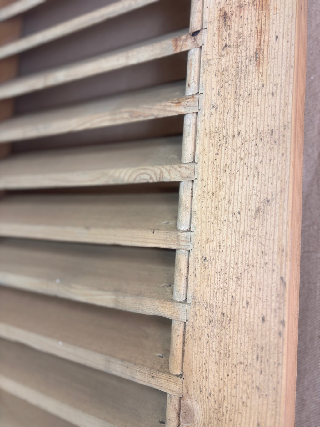Close-up of wooden slatted shutters on a brown background