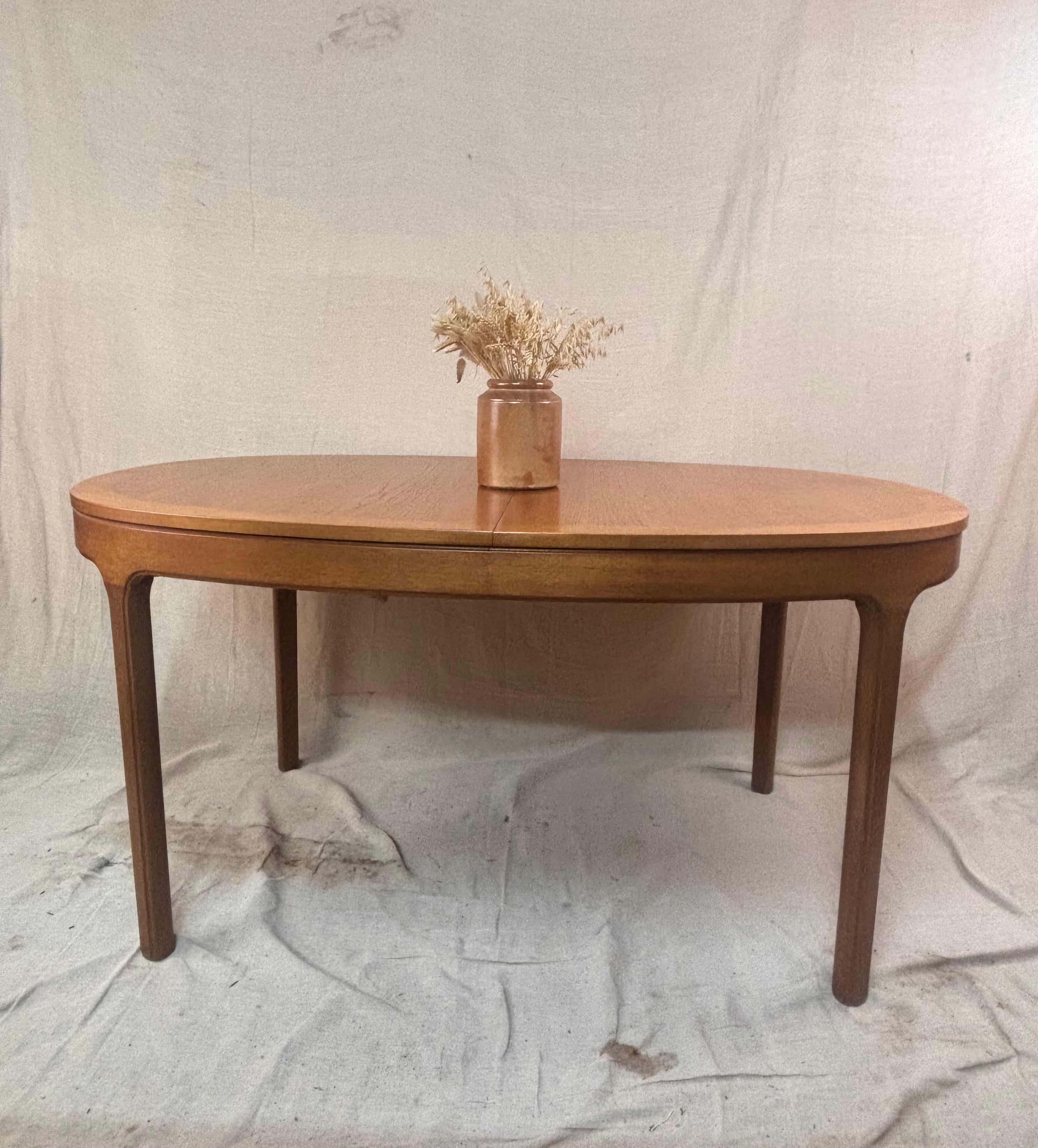 a wooden table with a vase of dried flowers on a cloth background