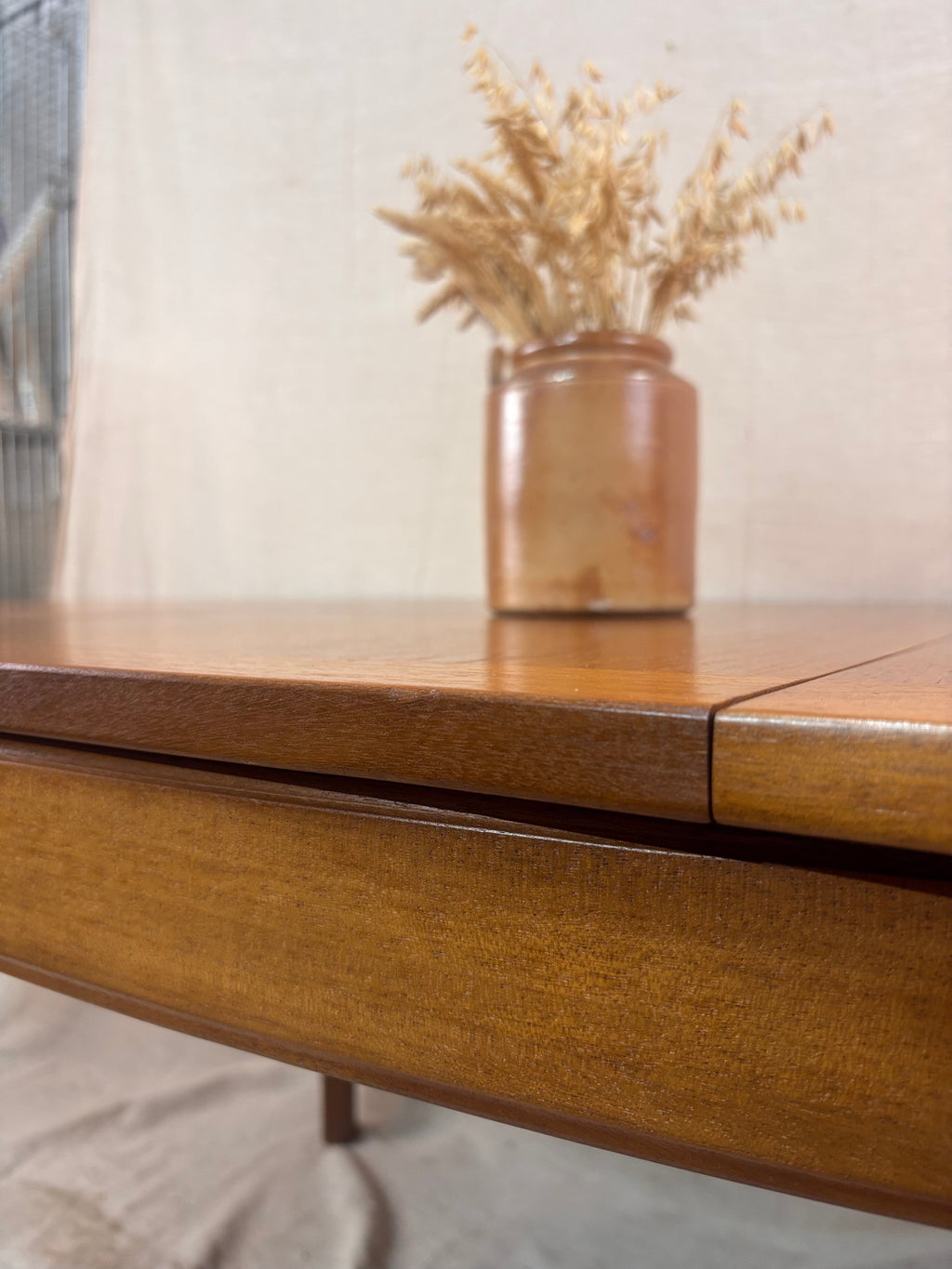 close up of a dining table with an out of focus vase of dried flowers