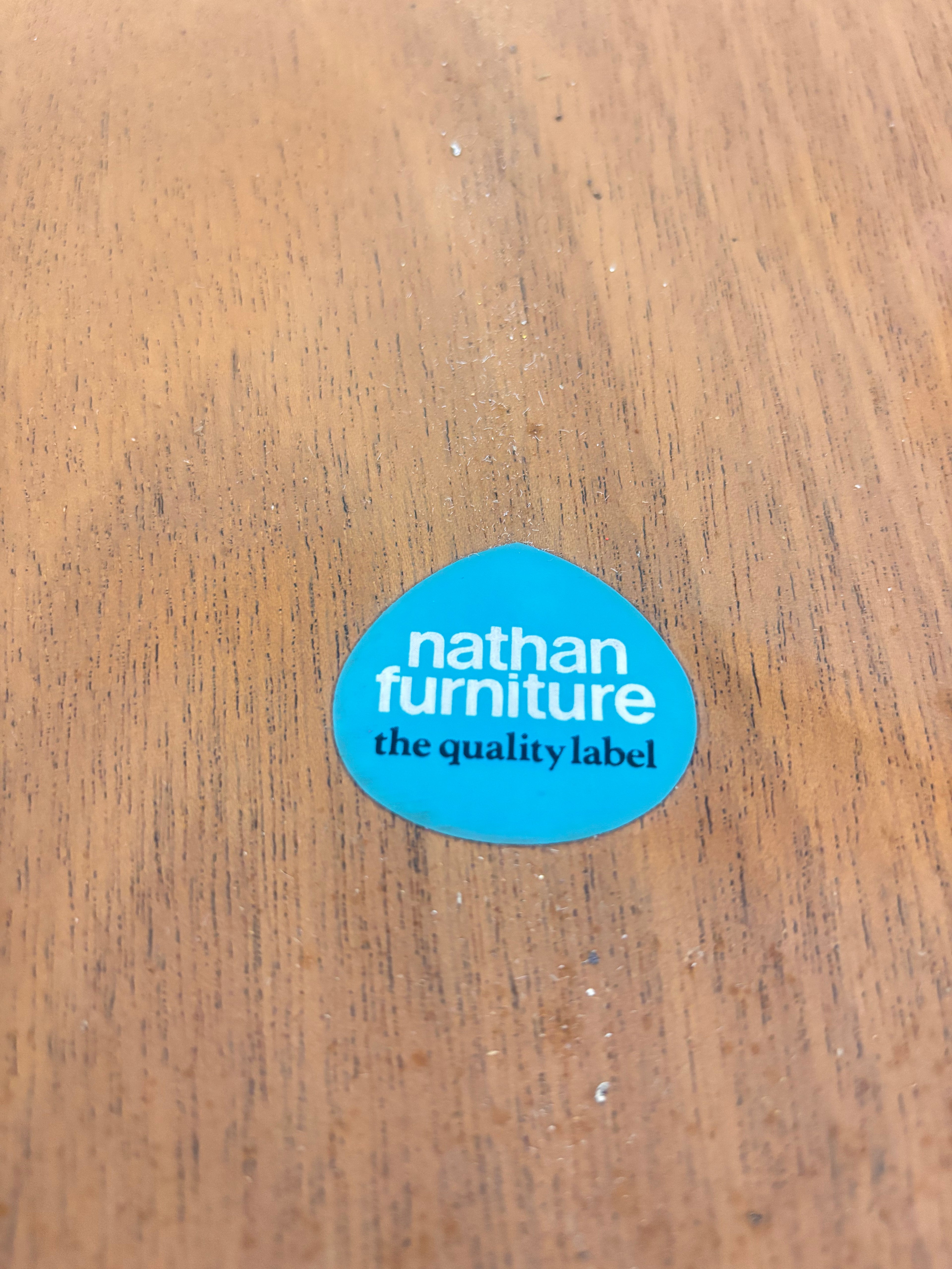 a blue sticker on a wooden surface nathan furniture the quality label