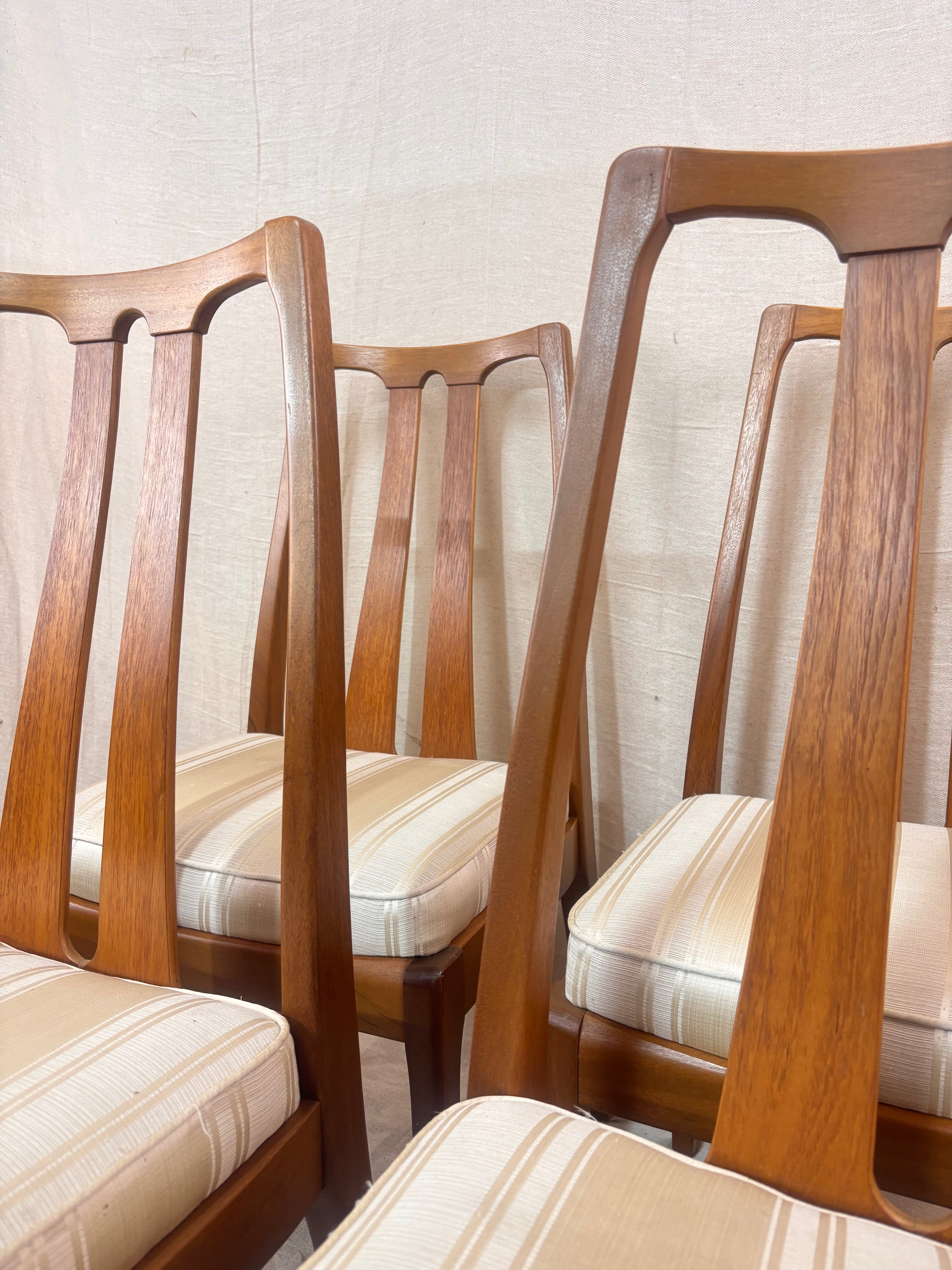 close up of 4 dining chairs against a light coloured wall