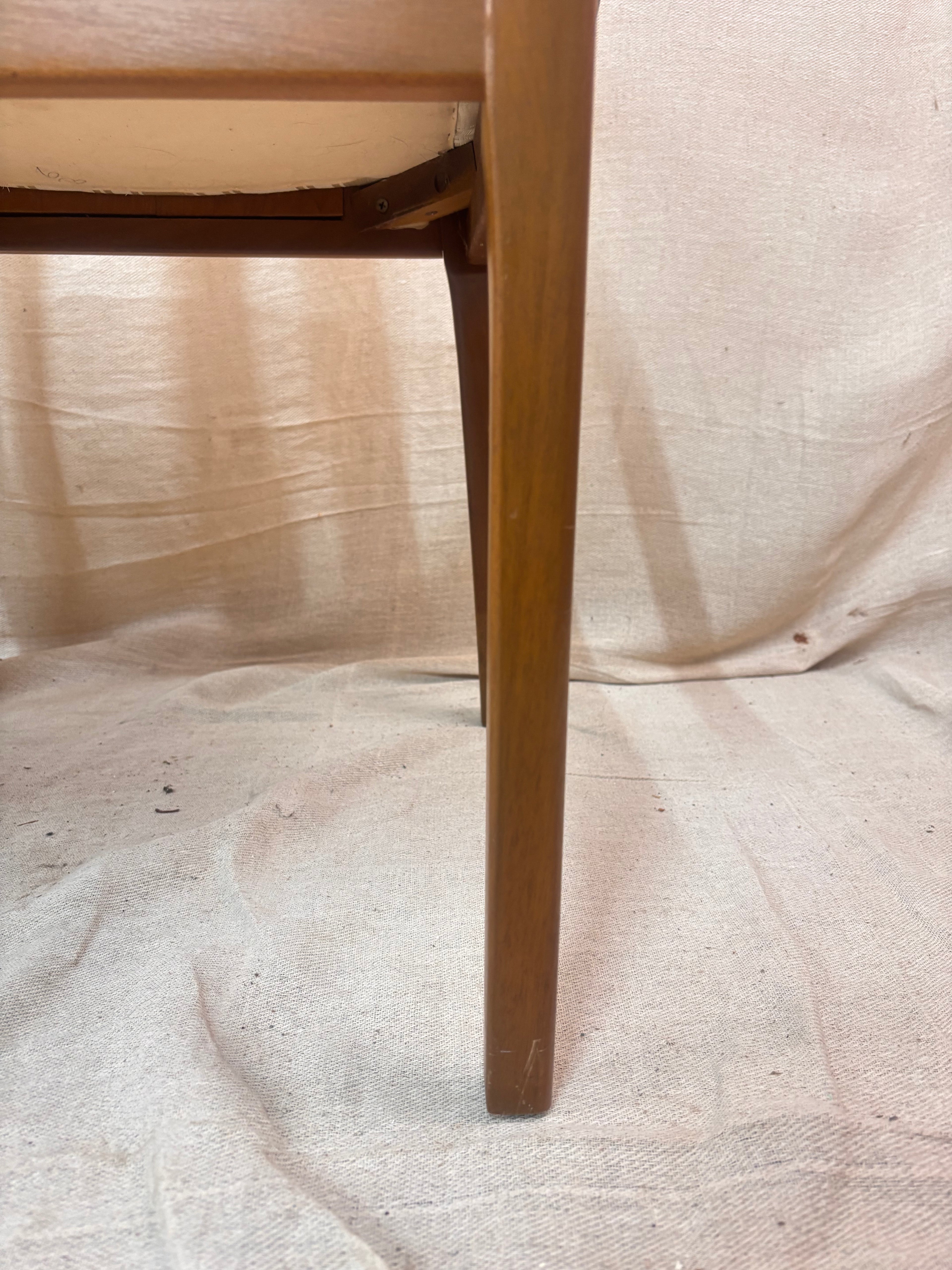 a wooden chair leg against a light coloured wall