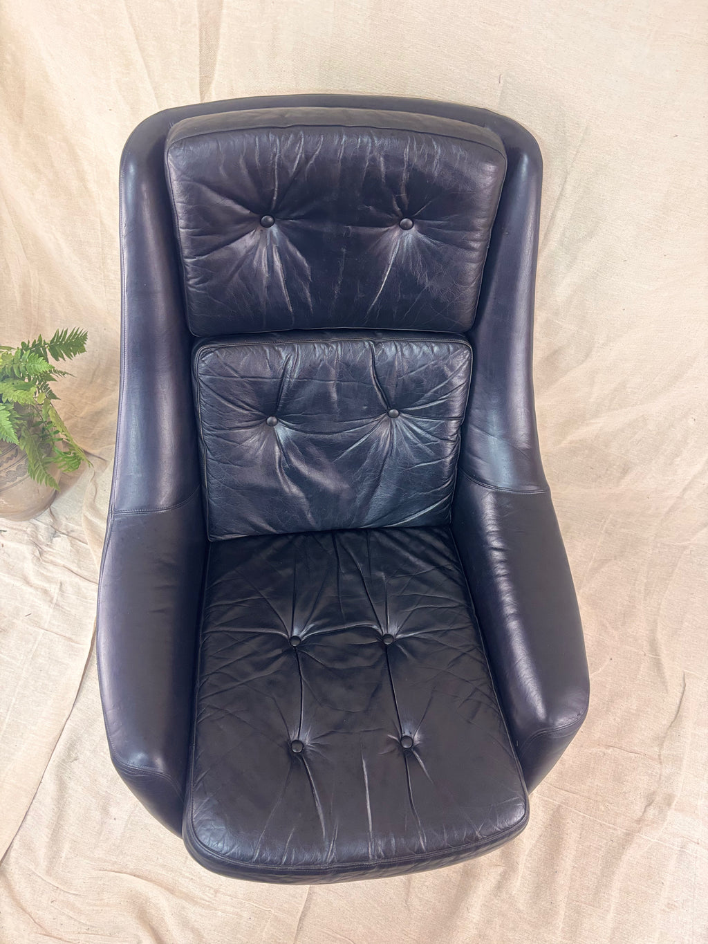 black leather armchair on a beige surface