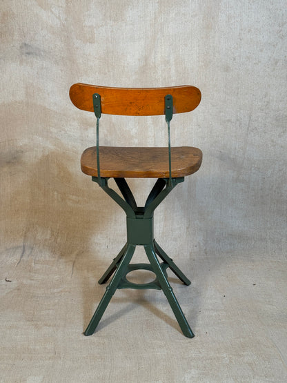Vintage industrial machinist chair with green steel frame, wooden seat. 