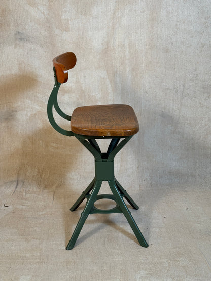 Vintage industrial machinist chair with green steel frame, wooden seat. 