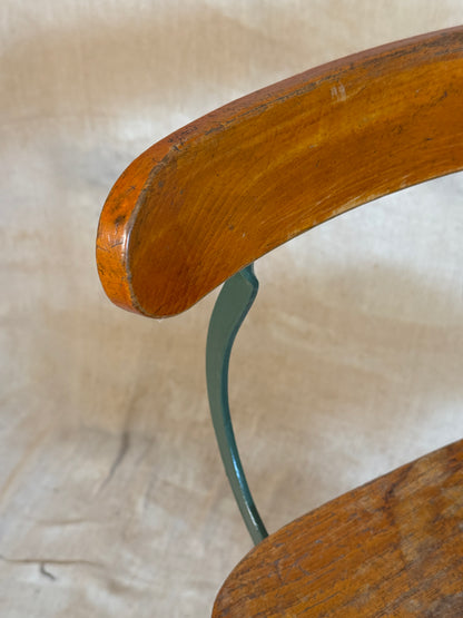 Vintage industrial machinist chair with green steel frame, wooden seat. 
