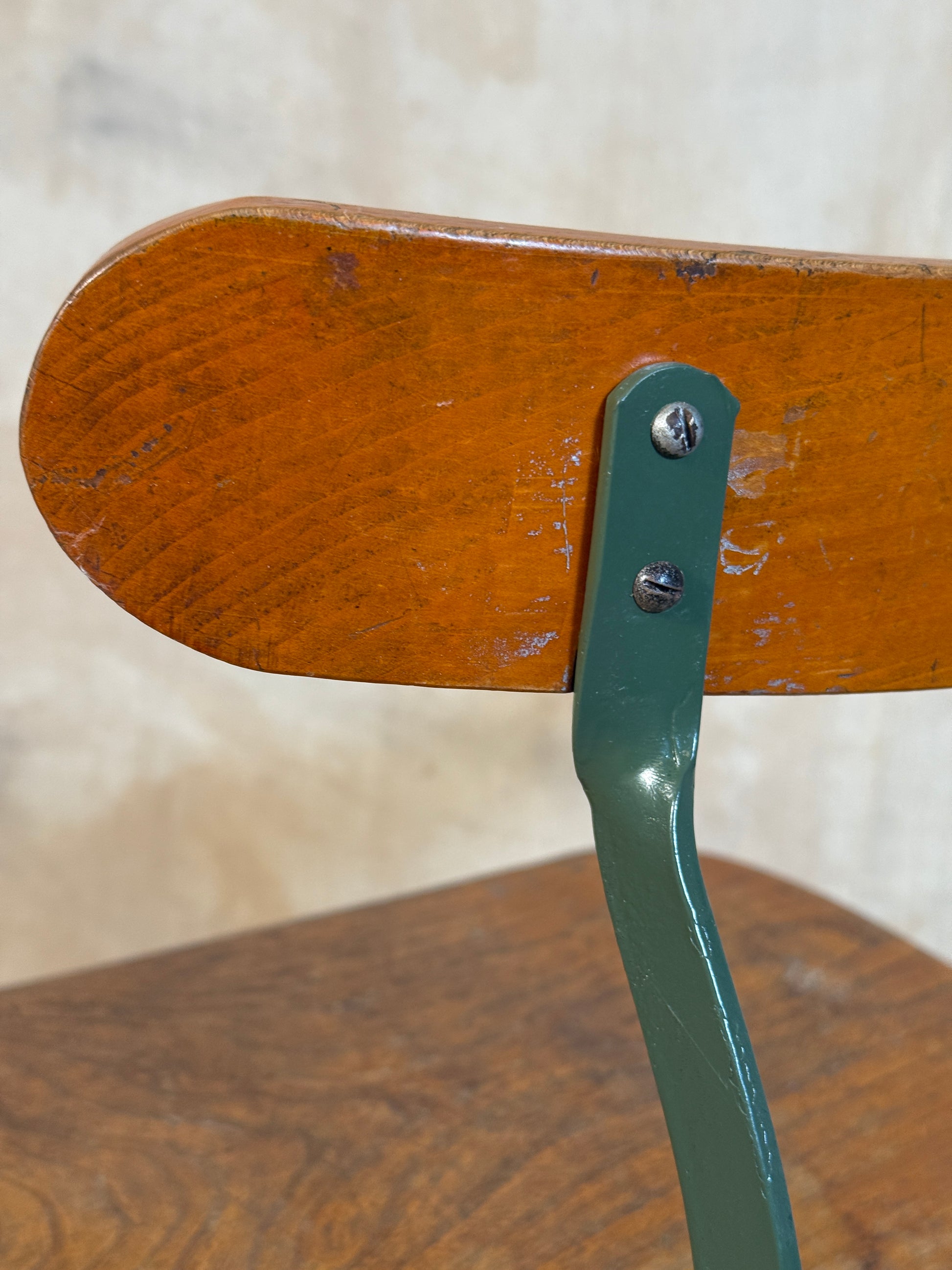 Vintage industrial machinist chair with green steel frame, wooden seat. 
