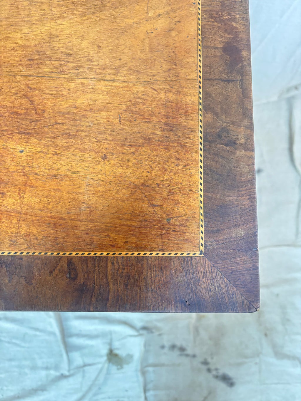 Wooden surface with a gold inlay on a textured white background