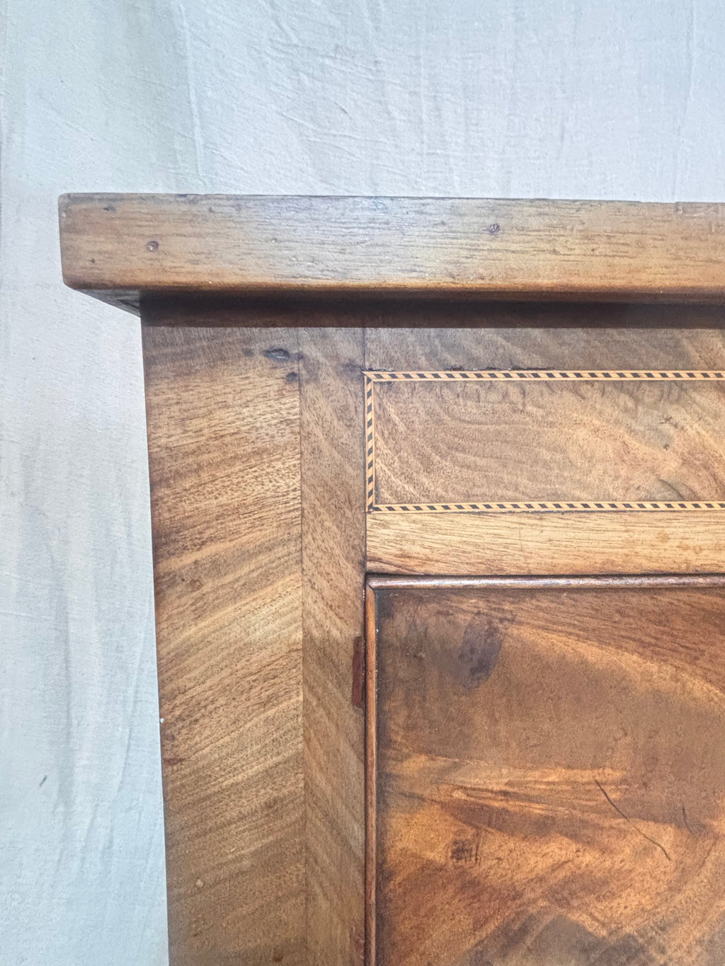 Close-up of a wooden cabinet with a light gray background