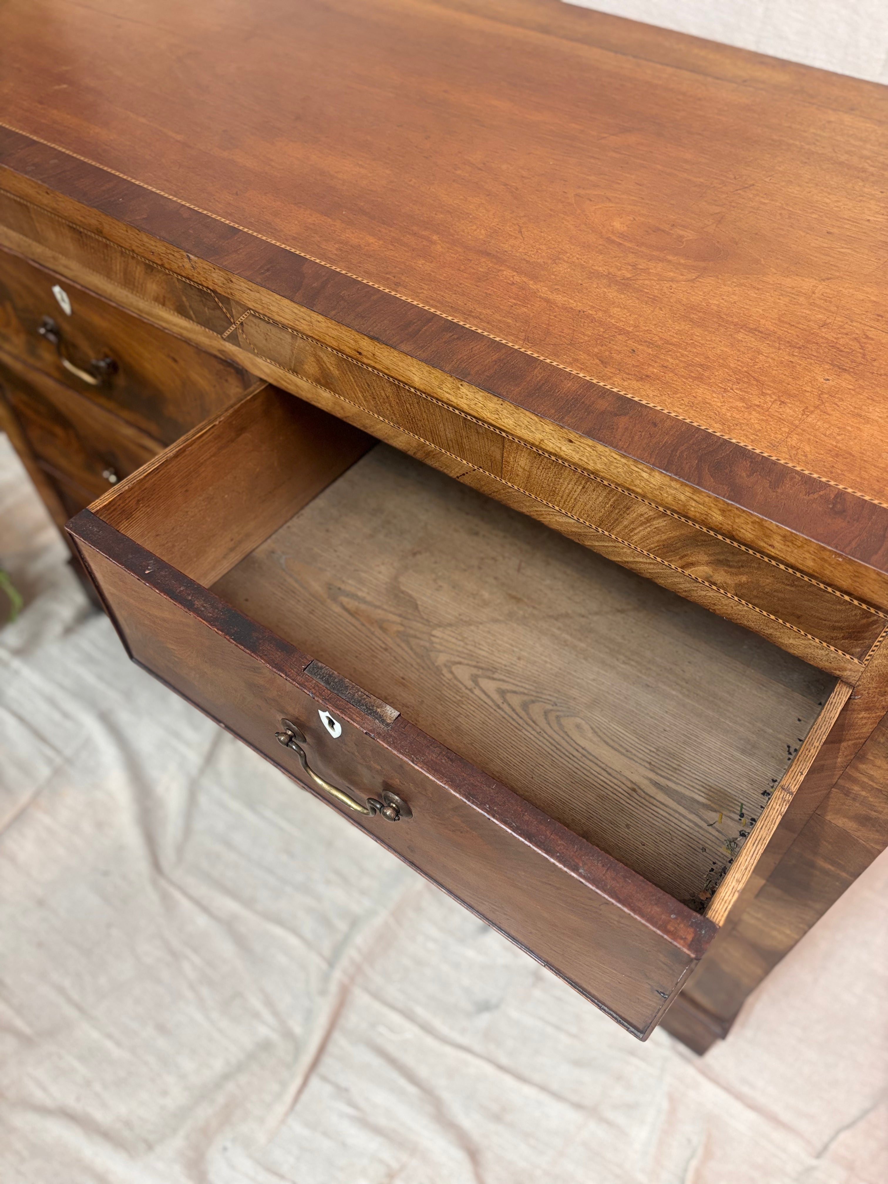 Wooden chest of drawers with an open drawer on a textured surface