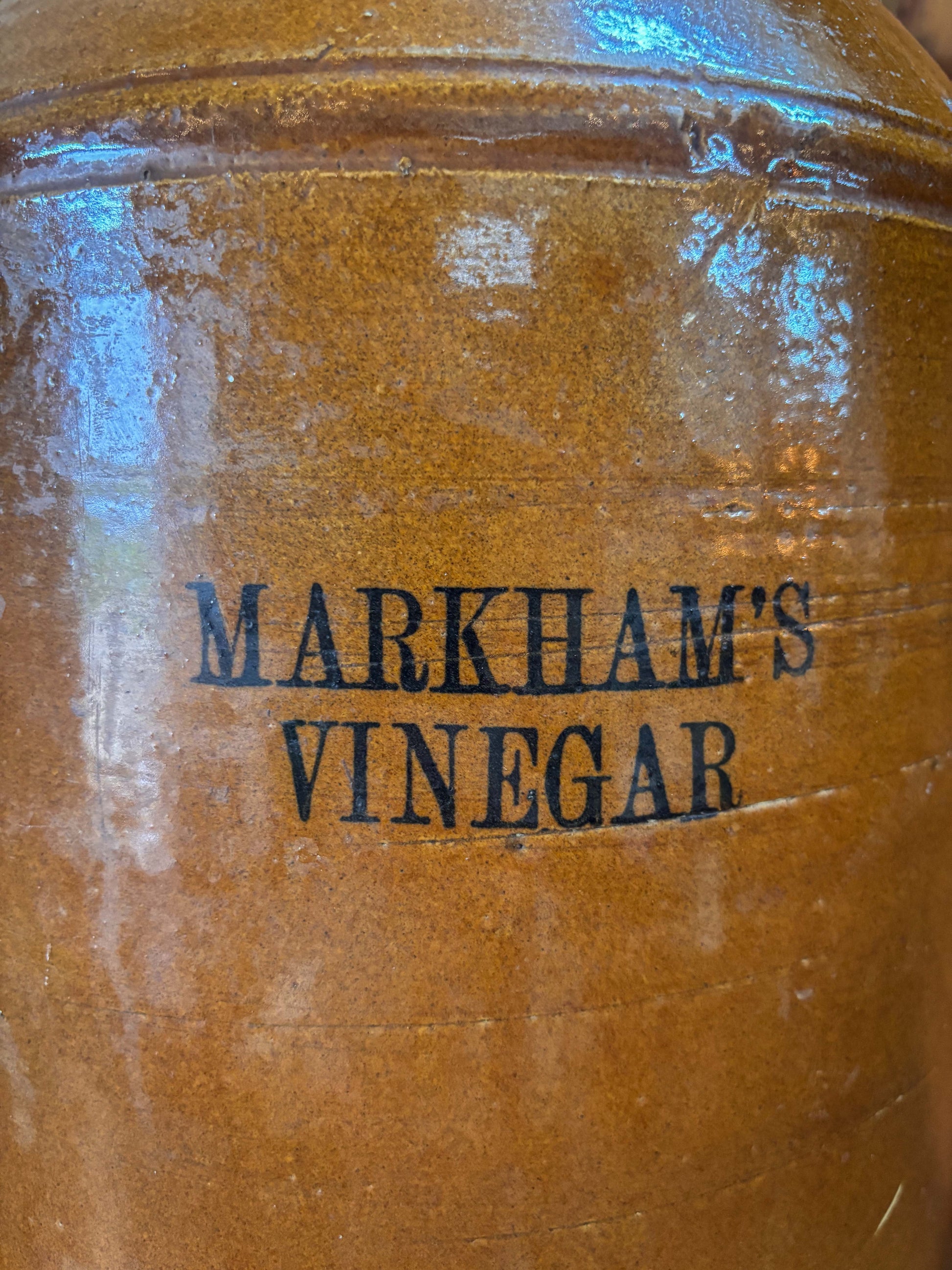 Brown jar with 'Markham's Vinegar' branding on a reflective surface