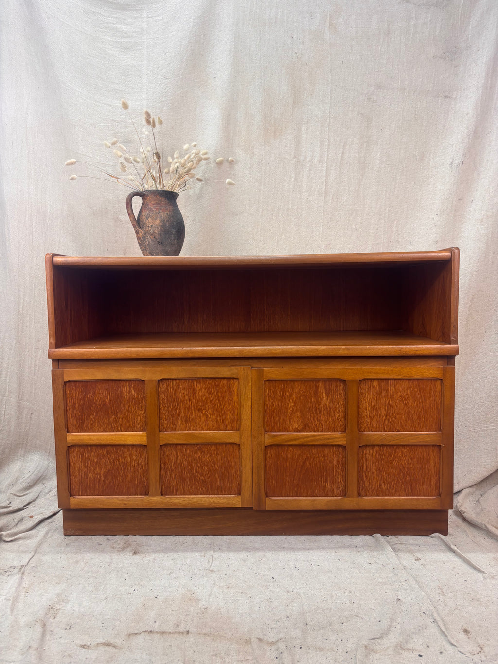 A Mid Century Modern Sideboard on a cream background. 