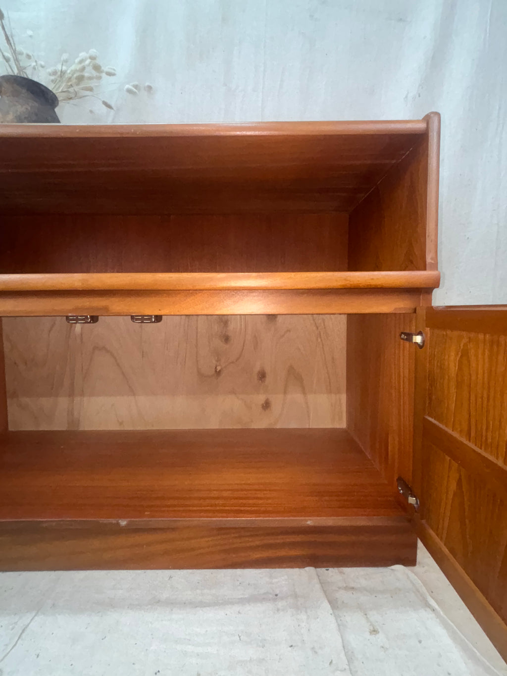 Interior of A Mid Century Modern Sideboard on a cream background. 
