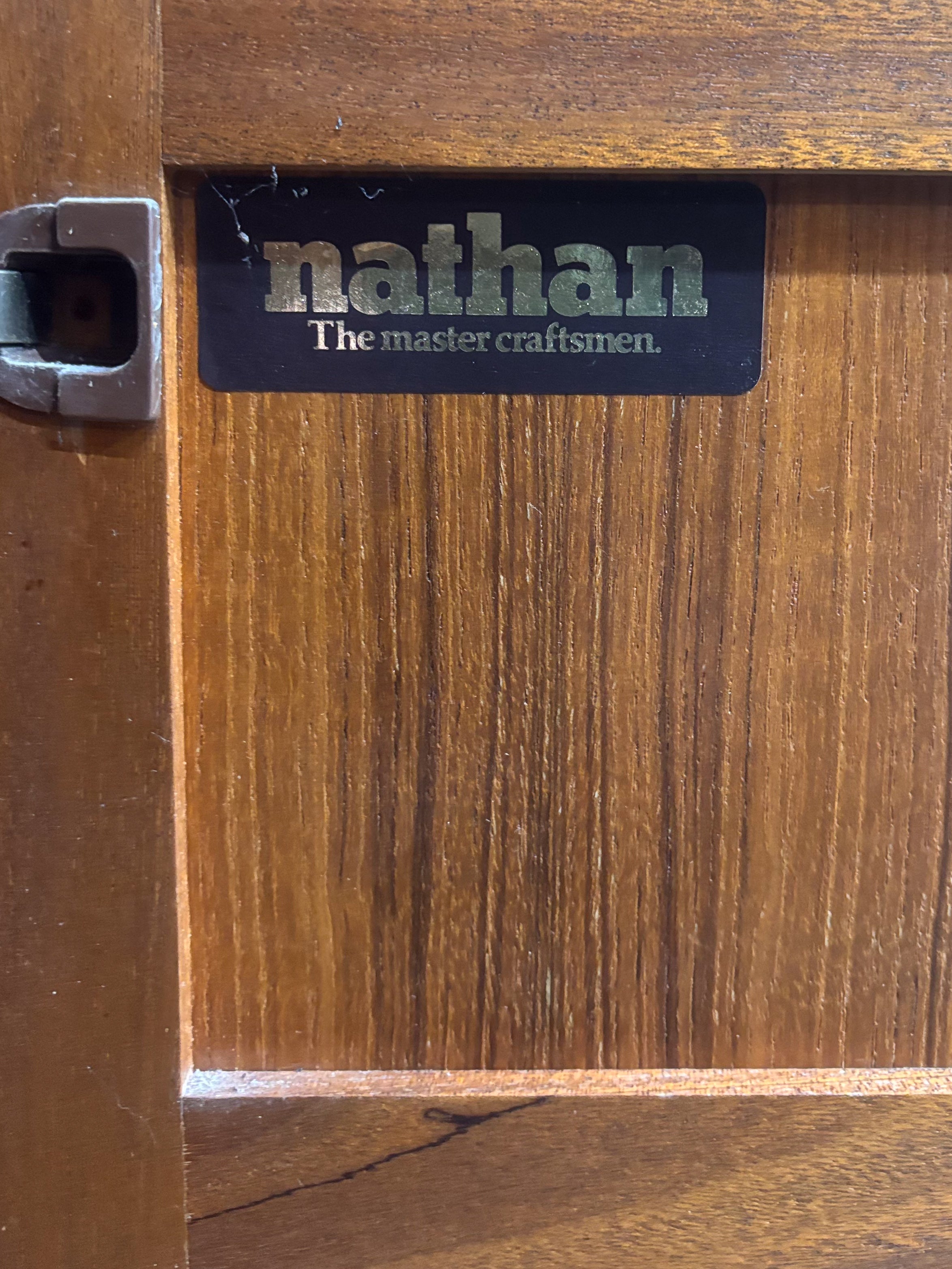 A nathan furniture black and gold sticker on a wooden surface