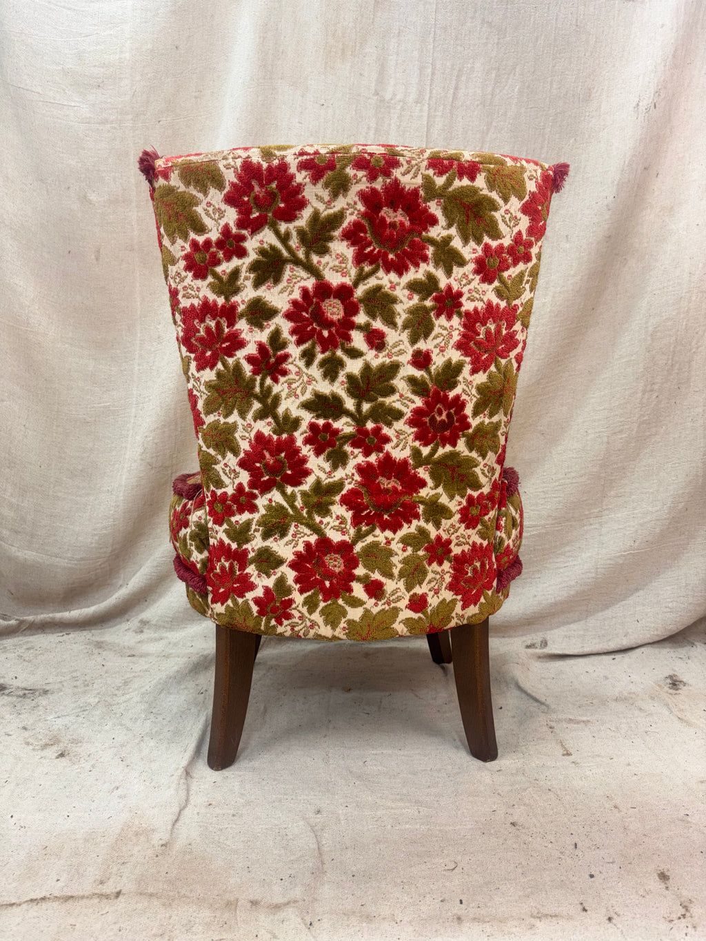 Floral-patterned chair with red and green flowers on a plain background