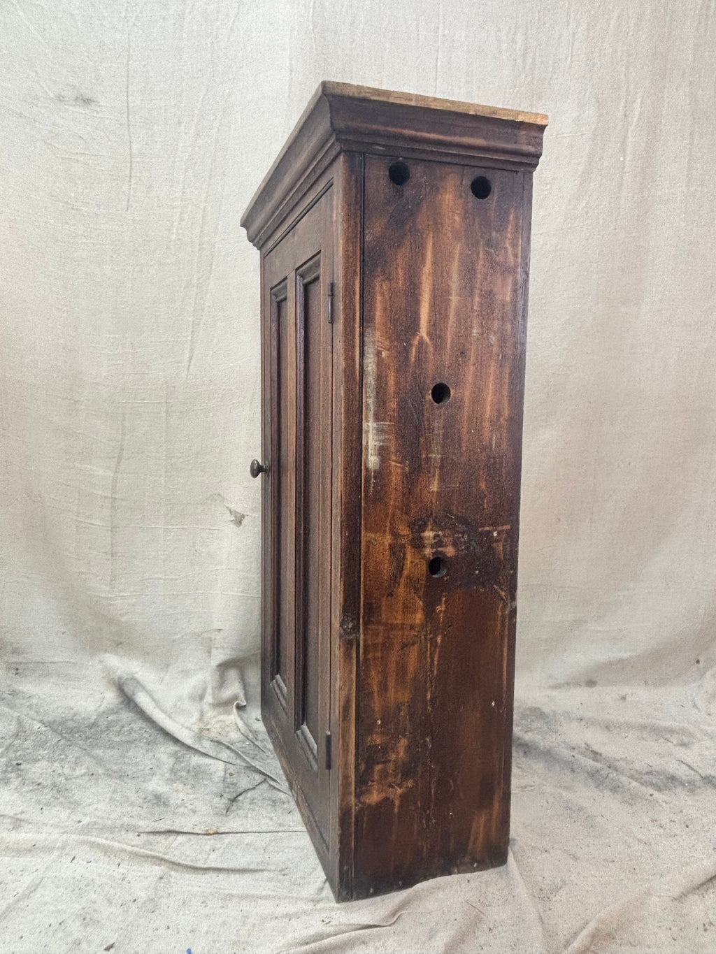 Wooden cabinet with a distressed finish on a plain background