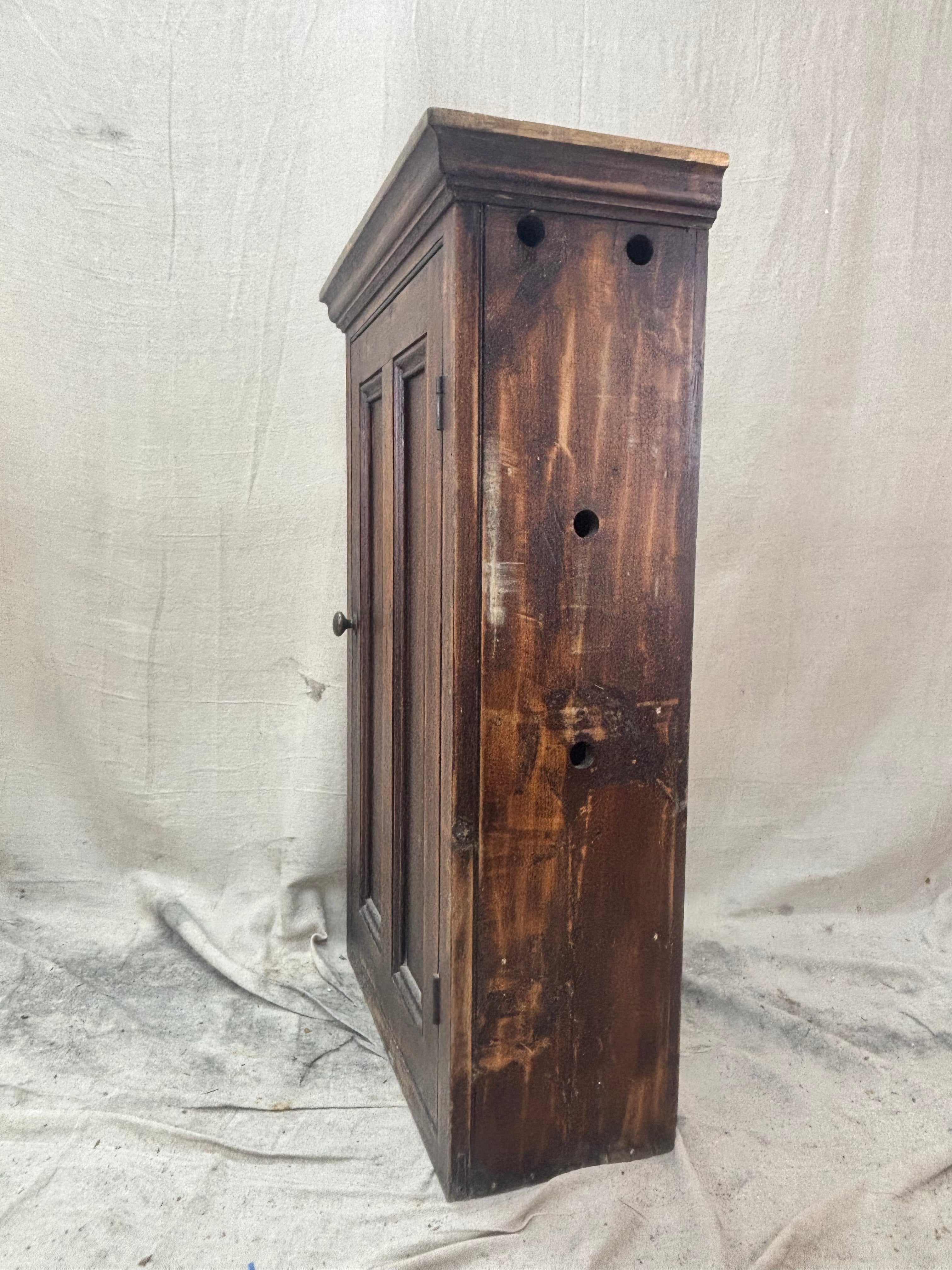 Wooden cabinet with a distressed finish on a plain background