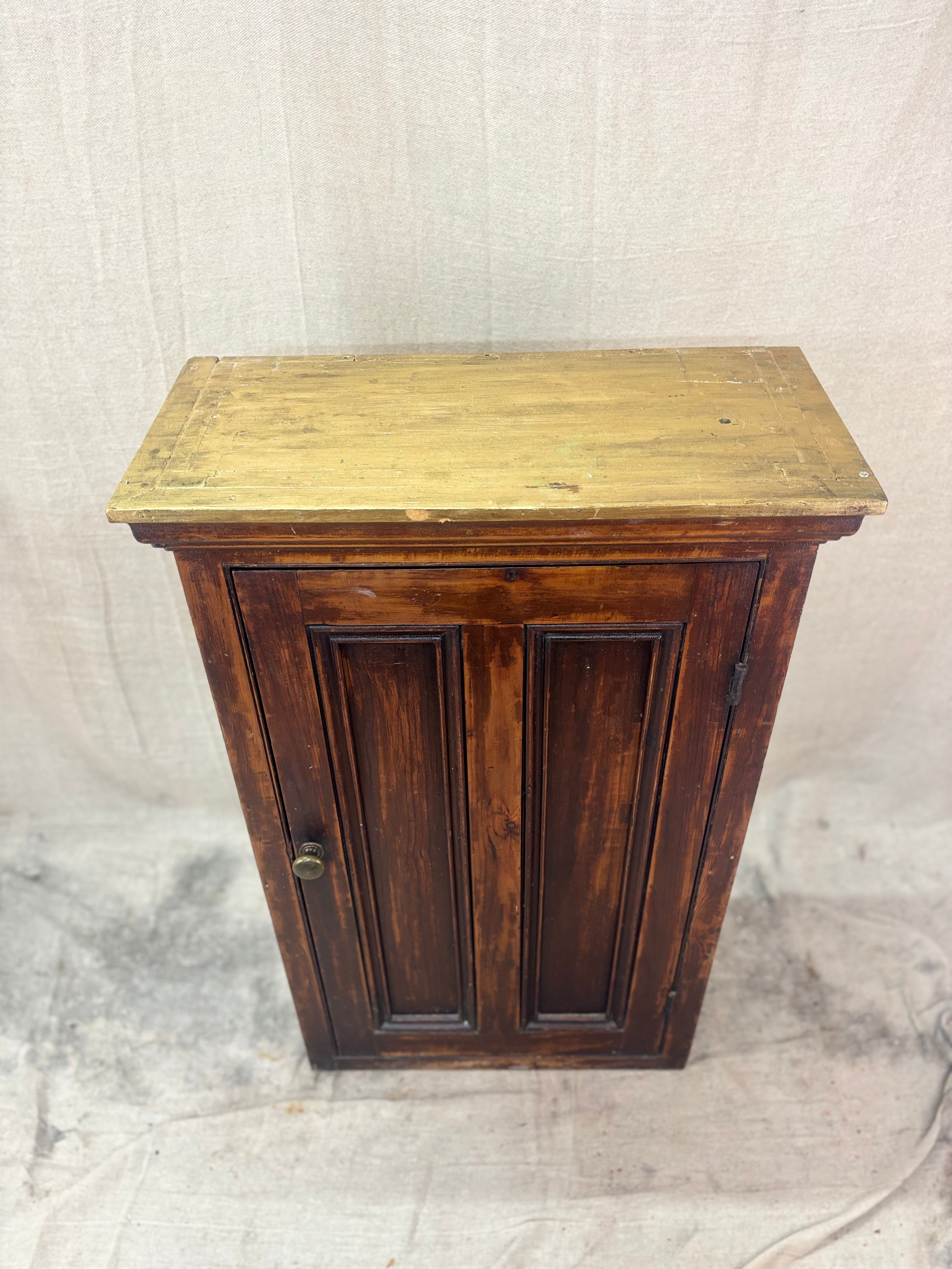 Wooden cabinet with a yellowish top on a textured beige background