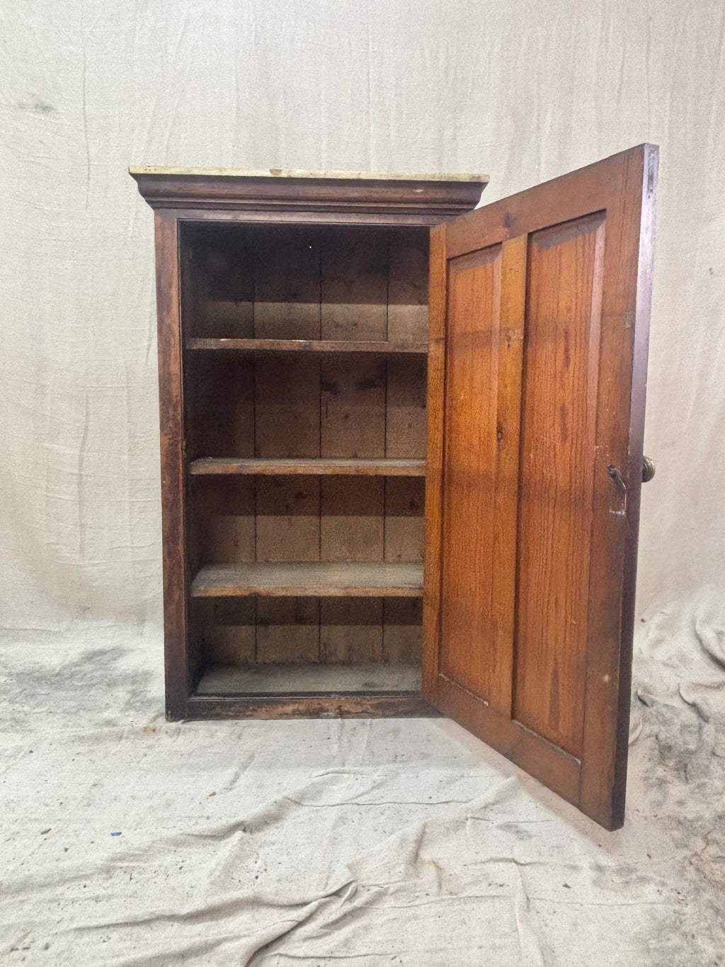 a wooden rustic cupboard with the door open and shelves within