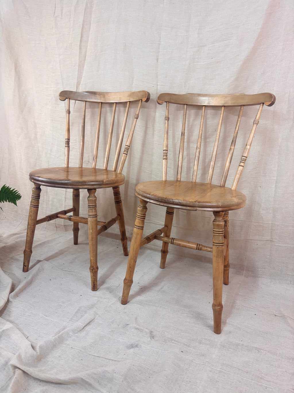 A pair of vintage wooden chairs on a cloth background