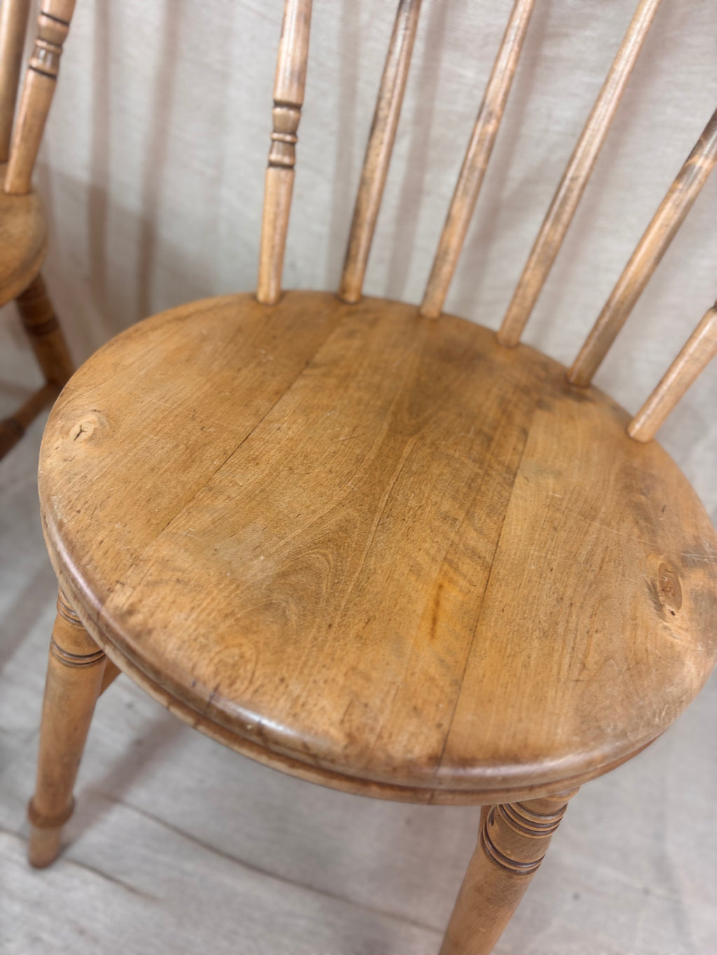 Wooden chair with a worn finish on a light wooden floor.