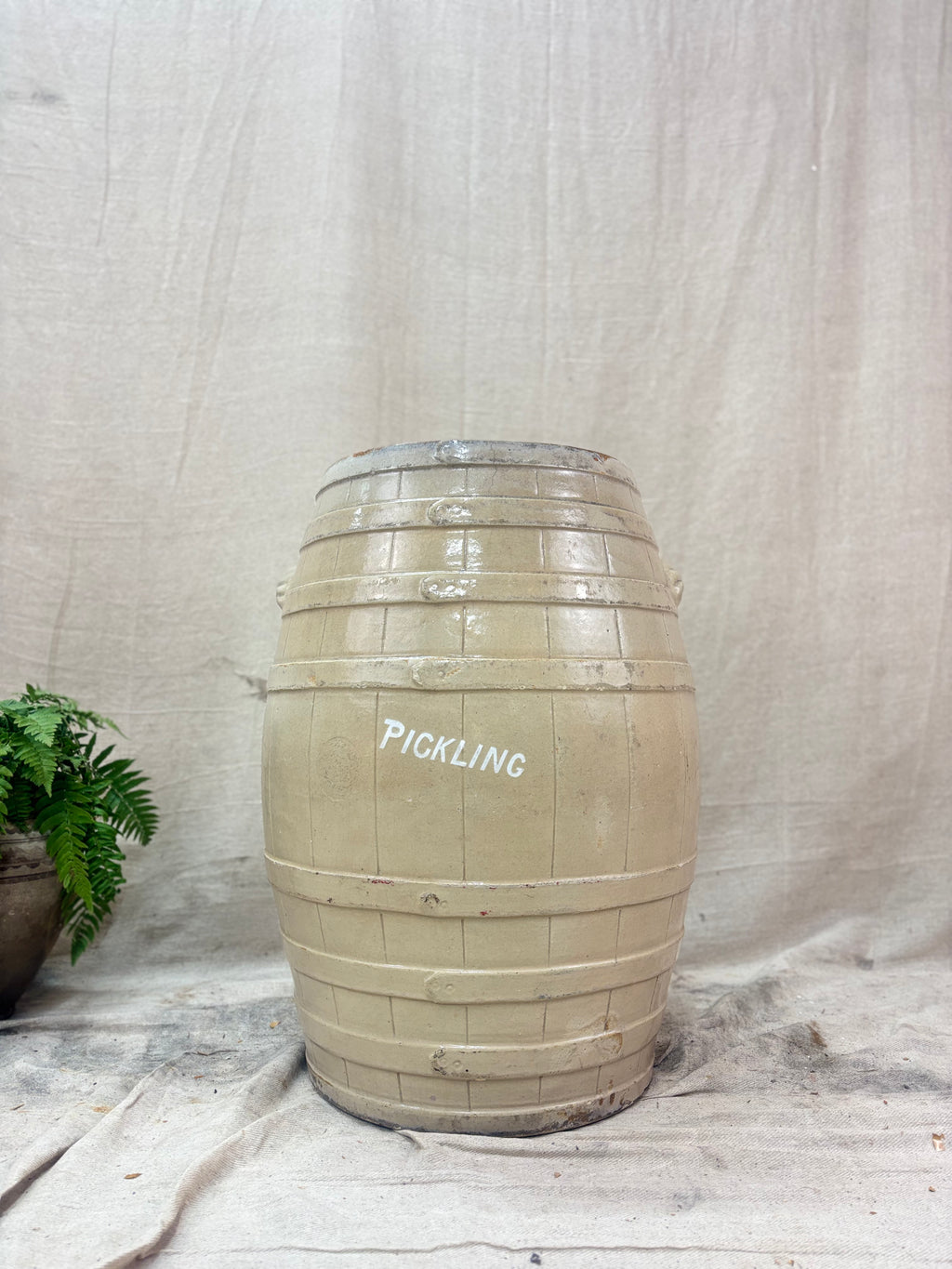 Stoneware barrel labeled 'PICKLING' on a textured fabric background