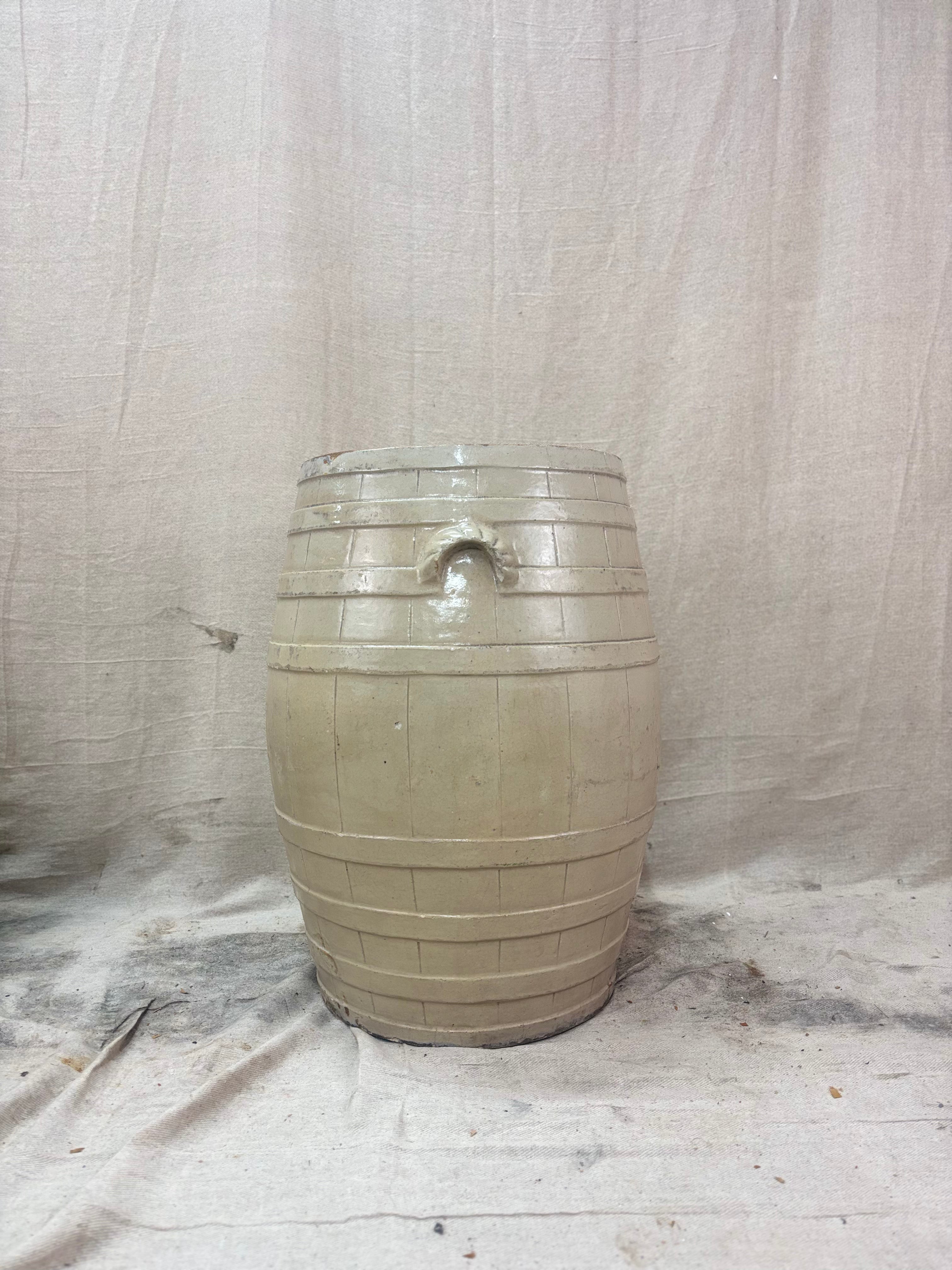 Beige ceramic barrel on a textured white background