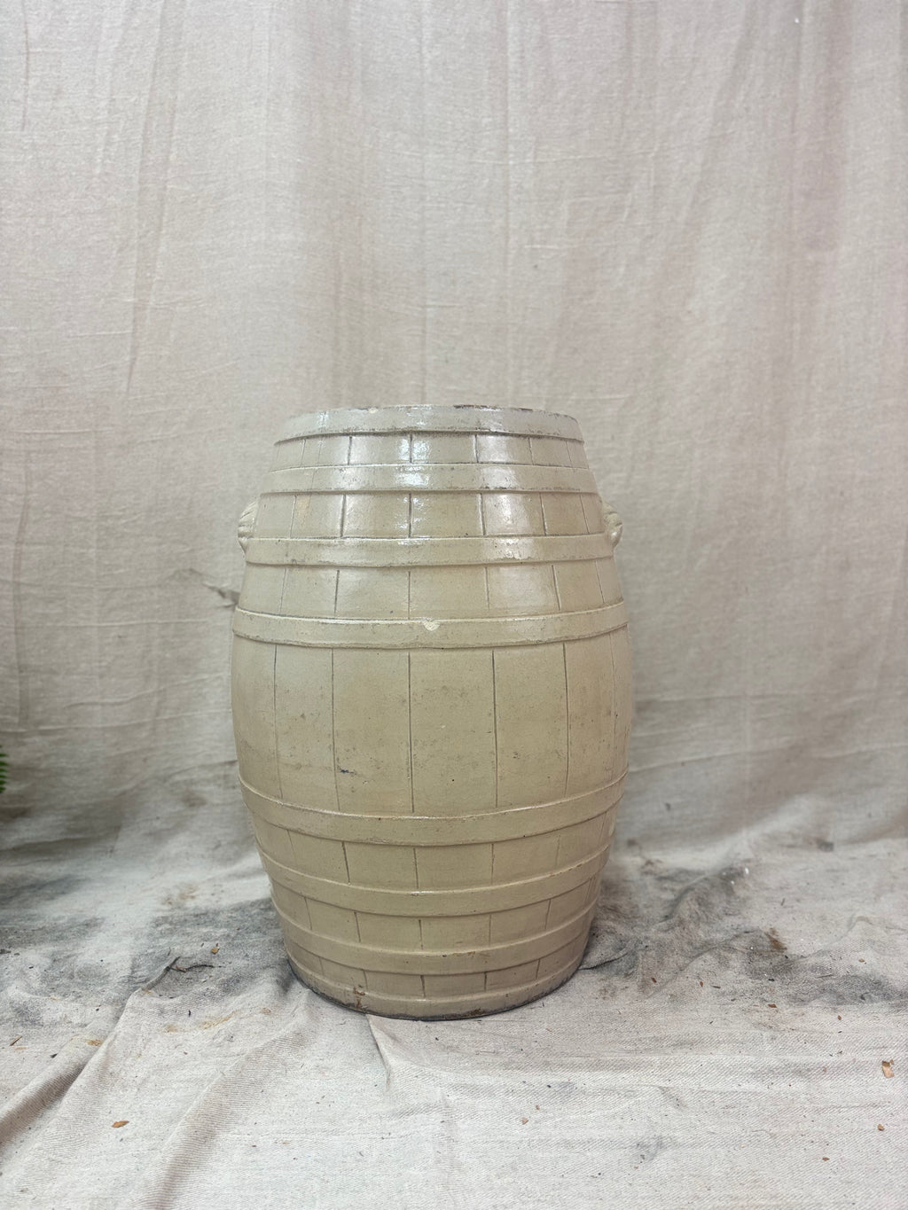 Beige stoneware barrel on a textured white background