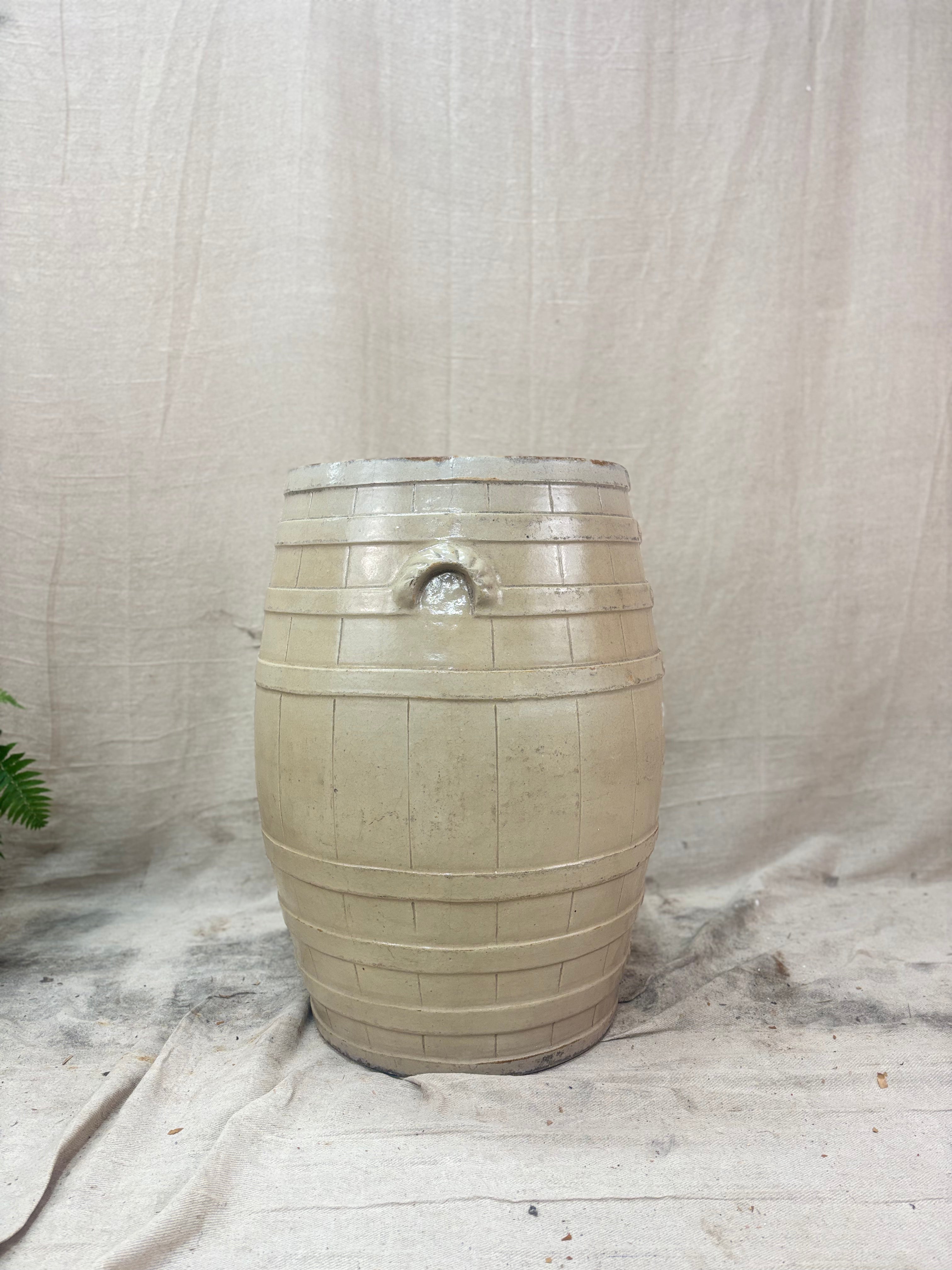 Beige ceramic barrel on a textured fabric background