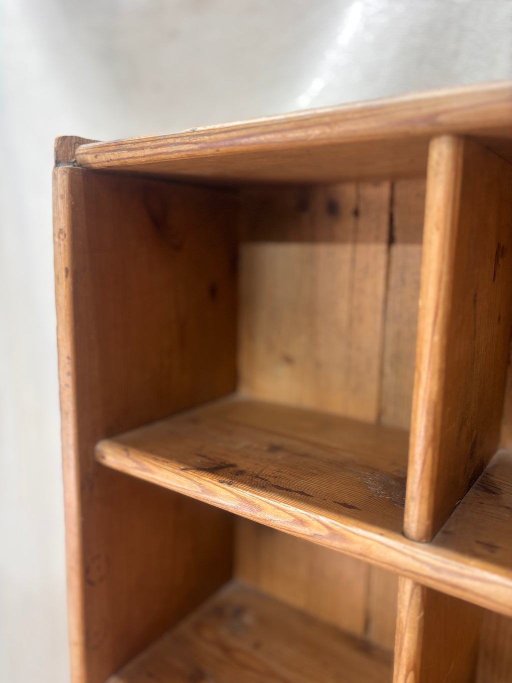 Wooden bookshelf with a white wall background