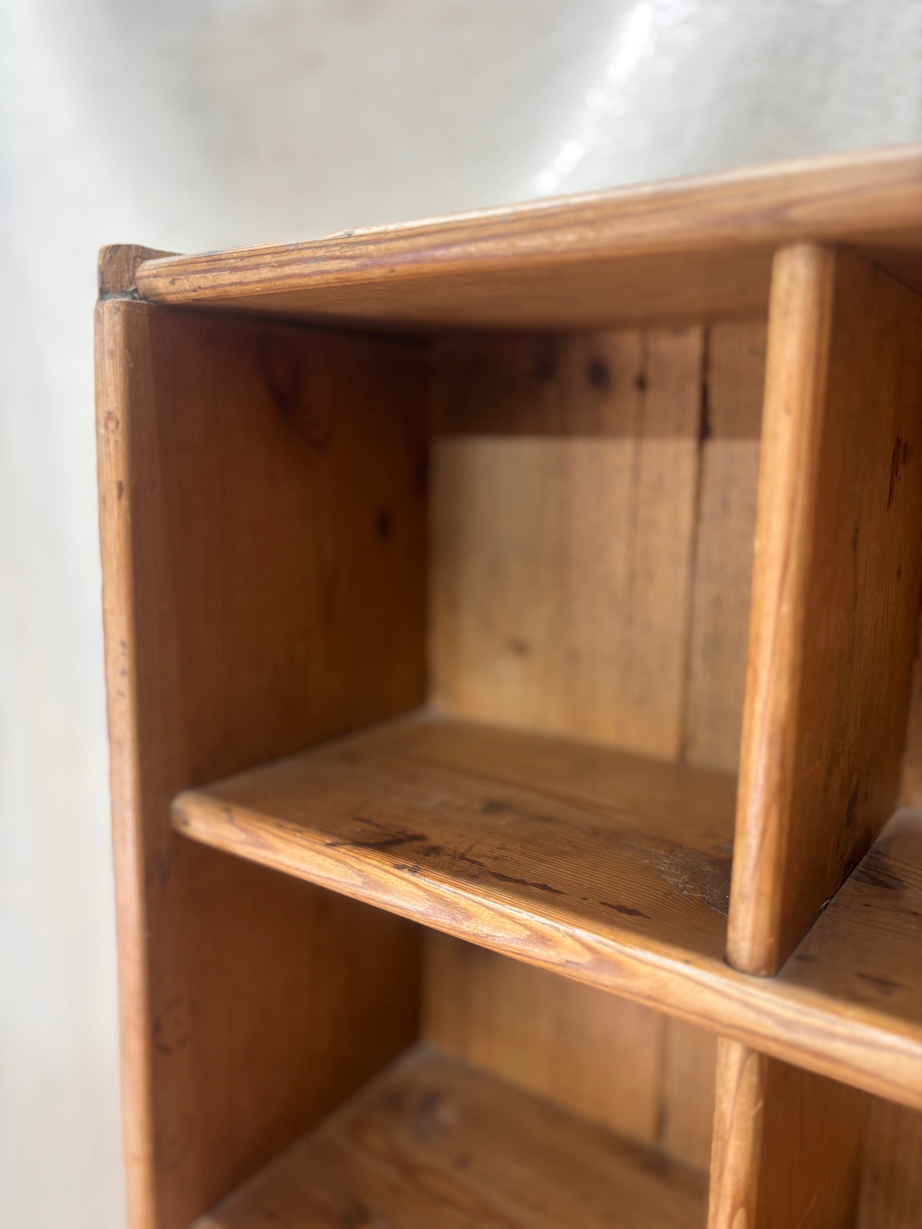 Wooden bookshelf with a white wall background