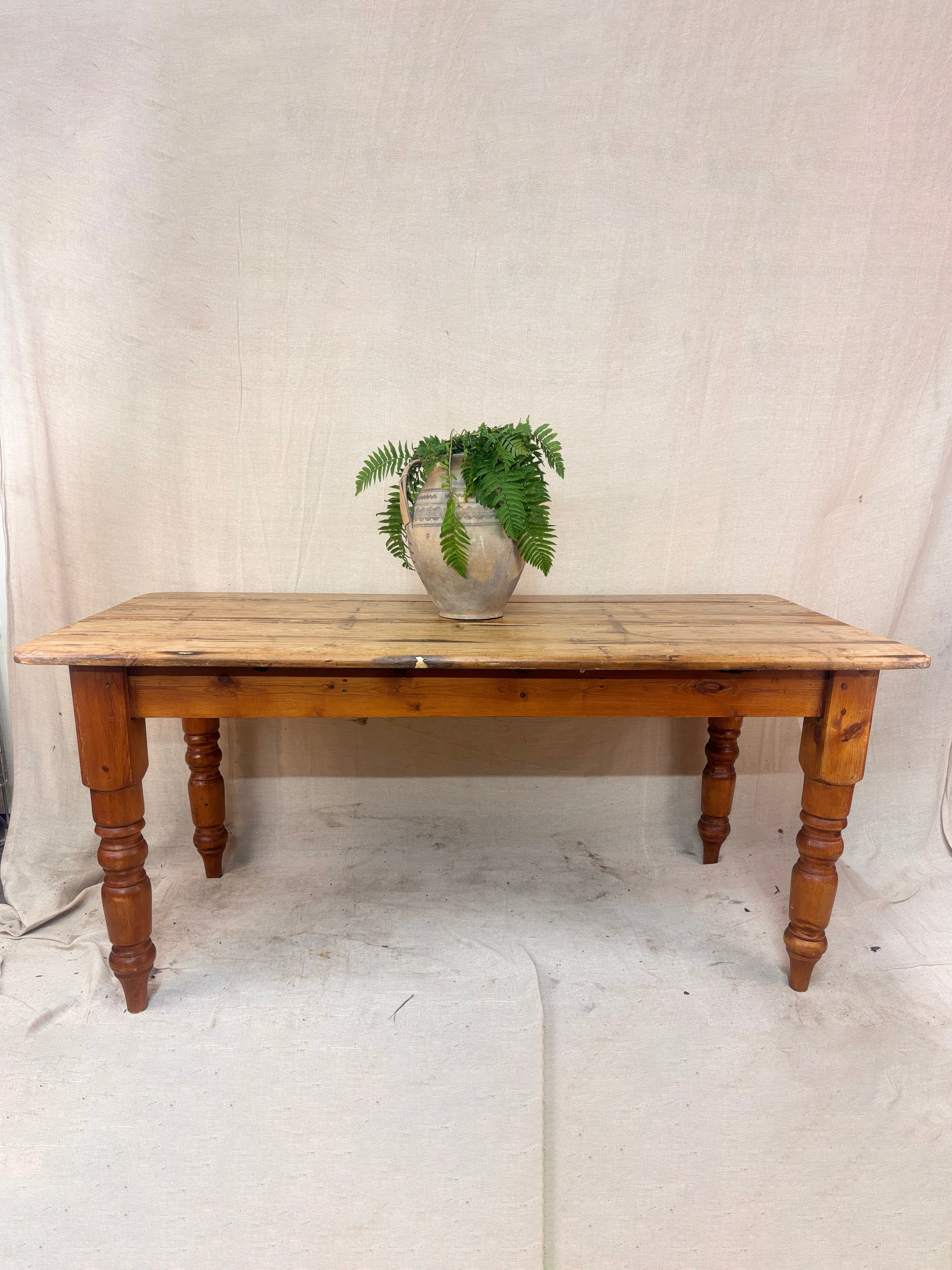 A Rustic Pine table with a potted plant on a cloth background 