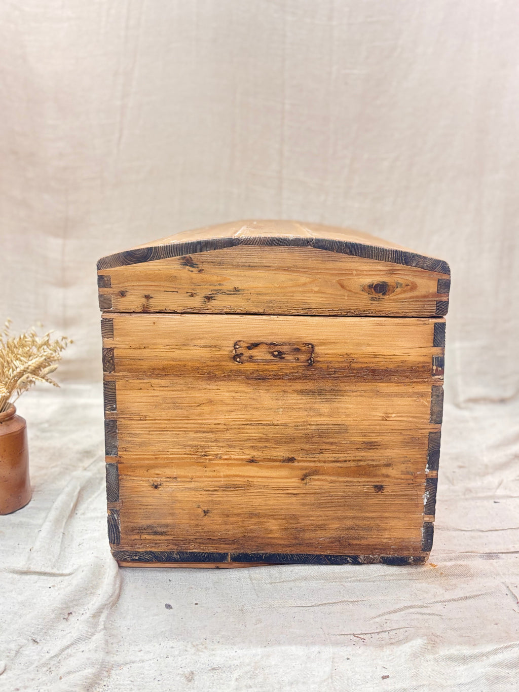 Wooden trunk with a rustic design on a light fabric background
