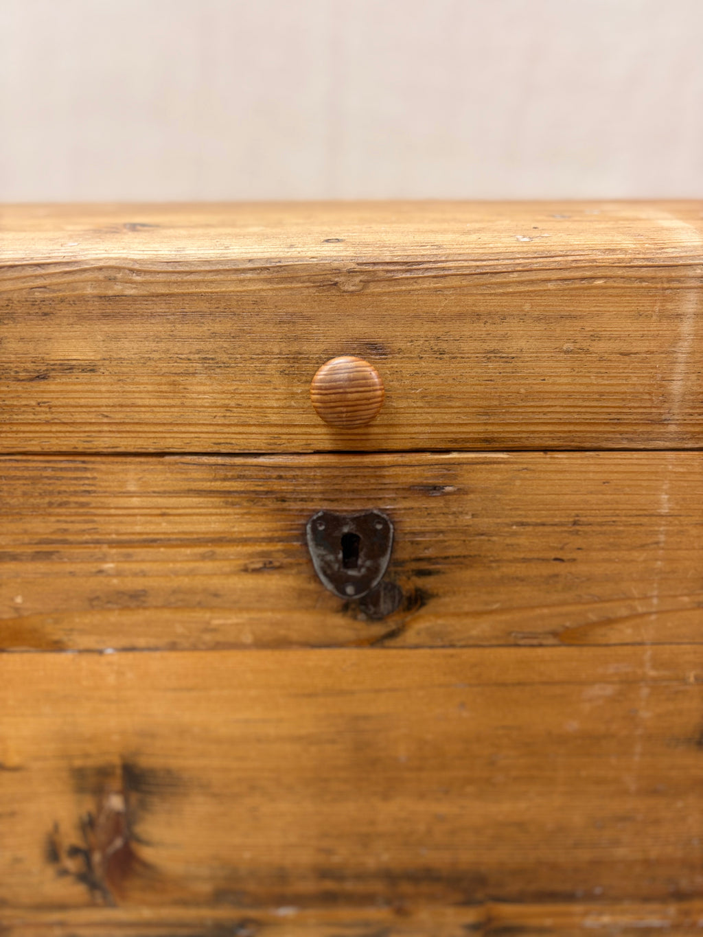 Close-up of a wooden drawer with a metal handle and keyhole.