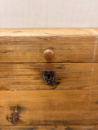 Close-up of a wooden drawer with a metal handle and keyhole.