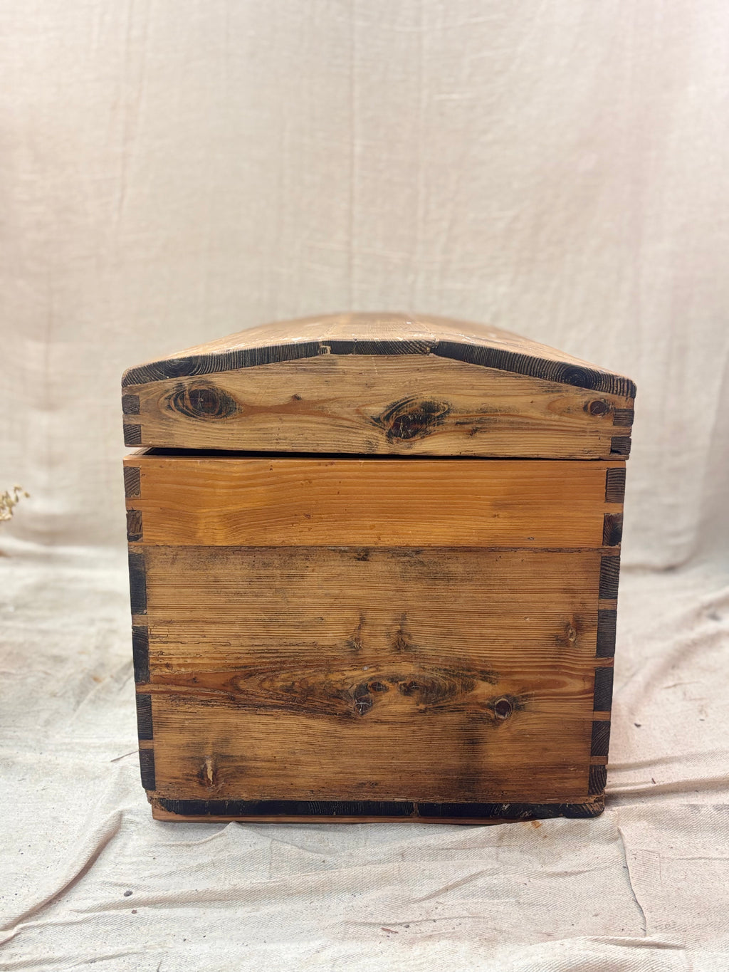 Wooden box with a lid on a textured beige background