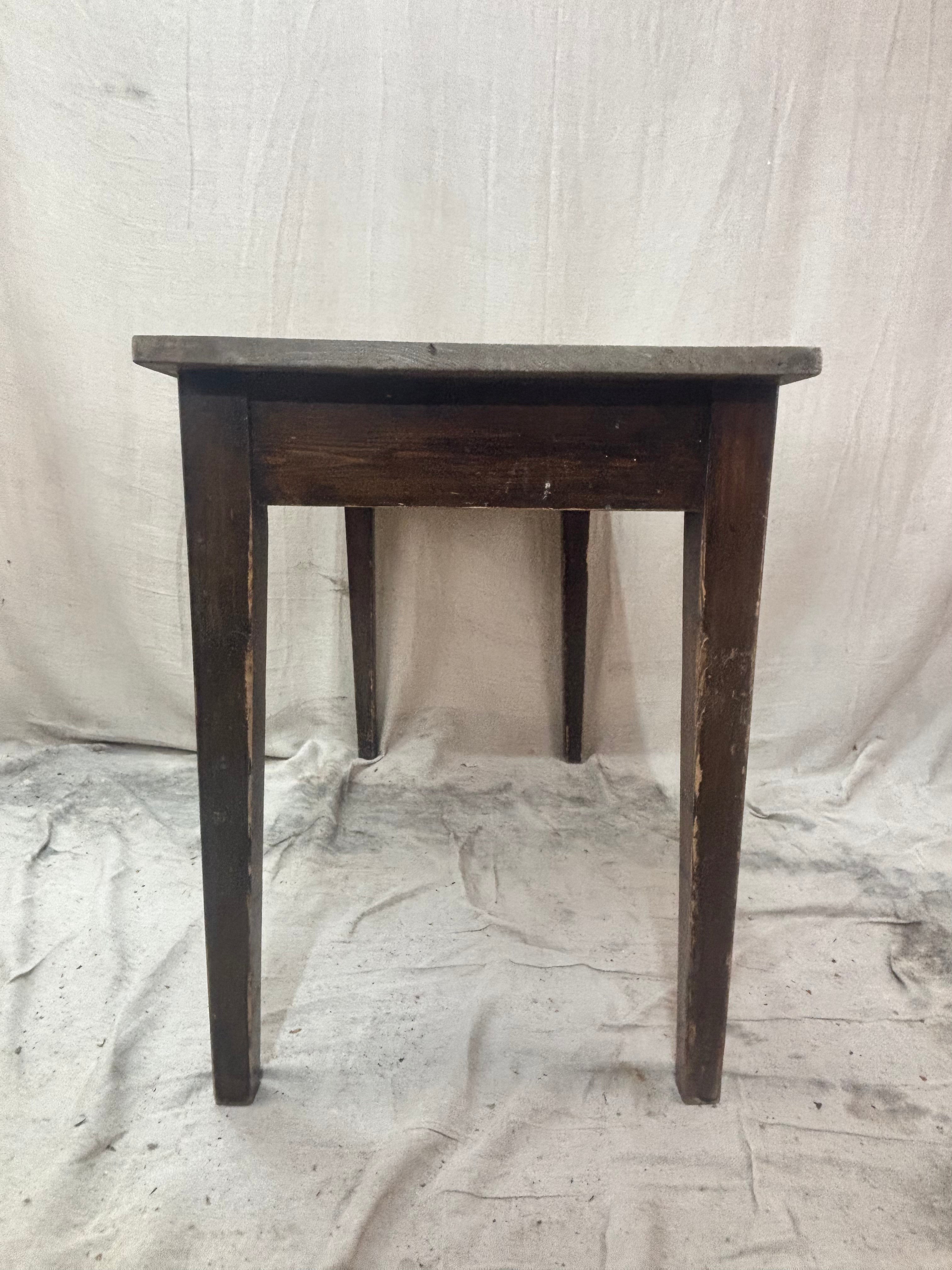 small pine table with dark legs and a light top on a light cloth background