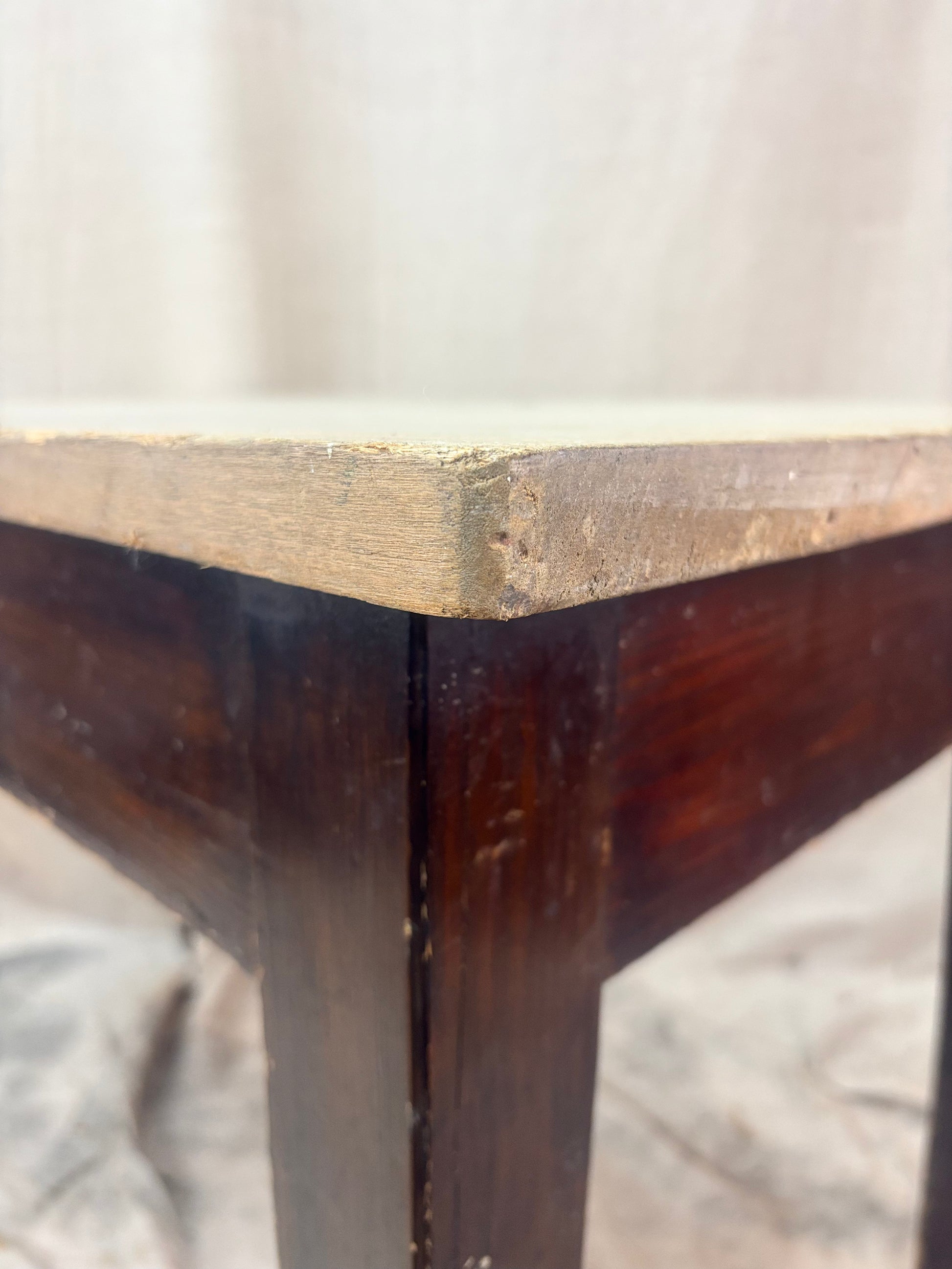Close-up of a wooden table corner with a plain background