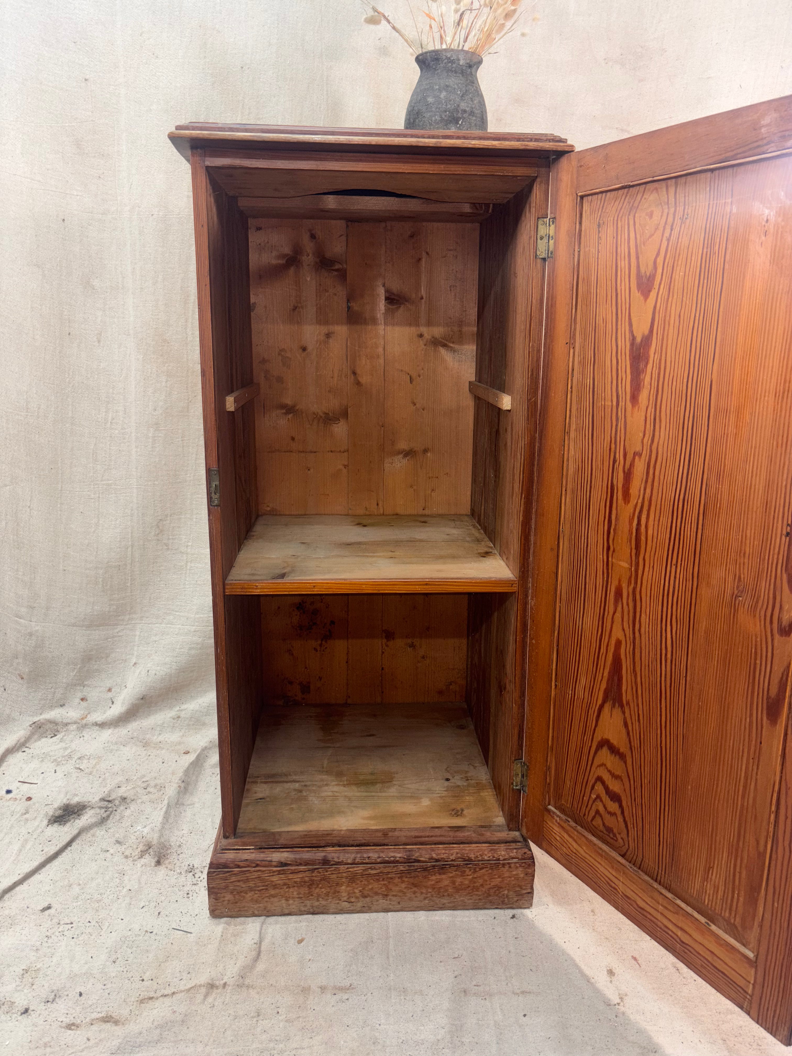 Wooden cabinet with open door on a textured surface