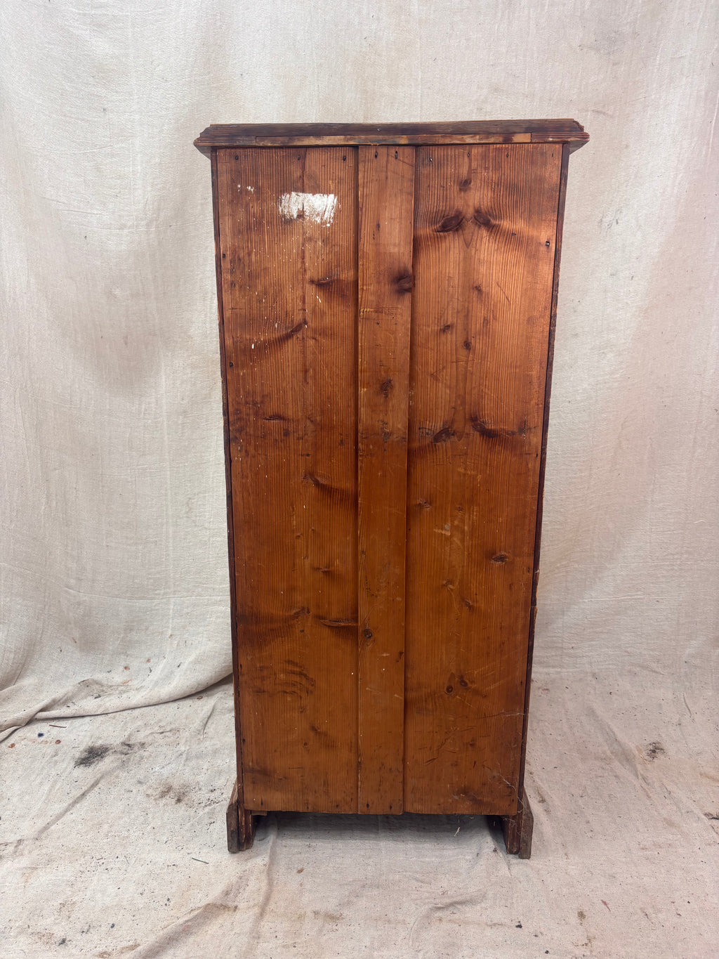Wooden cabinet with a distressed finish on a plain background