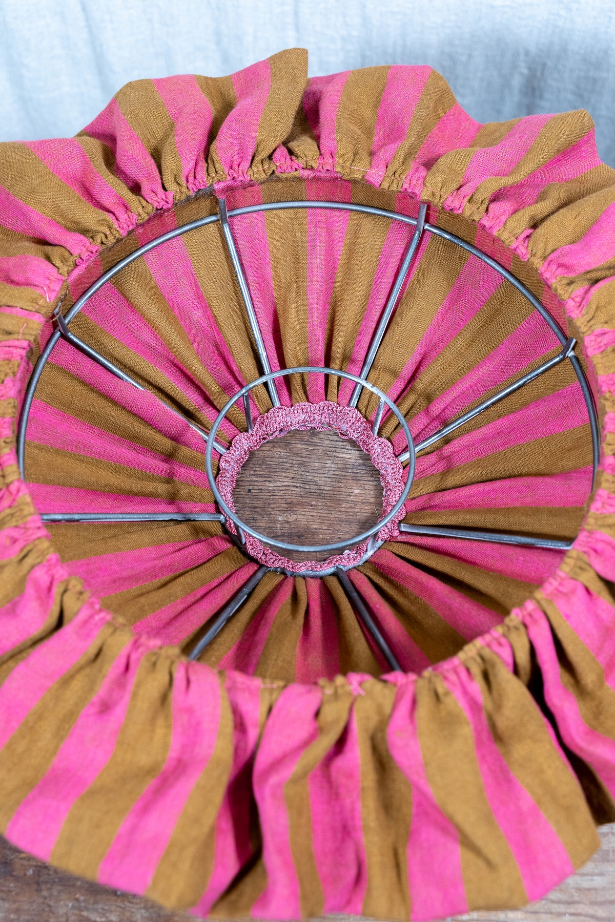 Handmade 12-inch linen carousel shade with raspberry and ochre stripes, vintage trim and pendant fitting. Cosy cottage style.