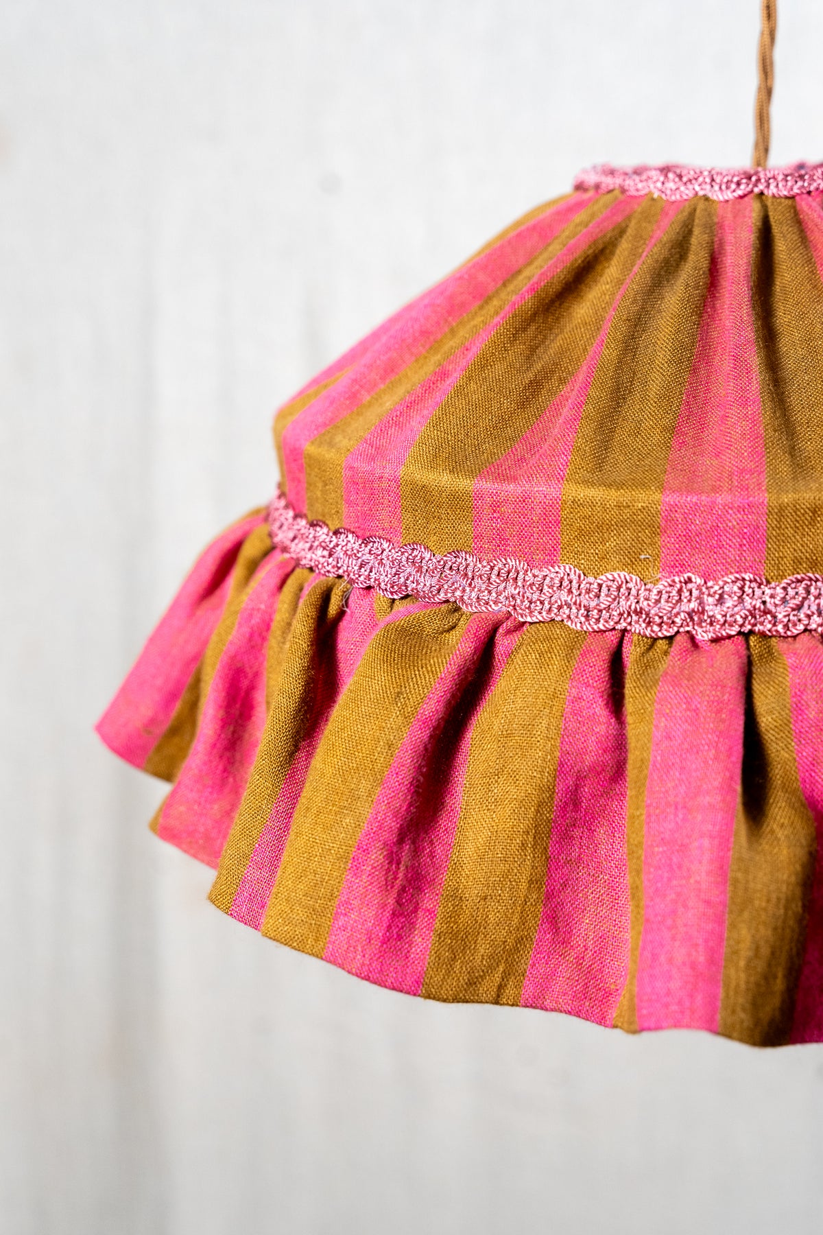 Handmade 12-inch linen carousel shade with raspberry and ochre stripes, vintage trim and pendant fitting. Cosy cottage style.