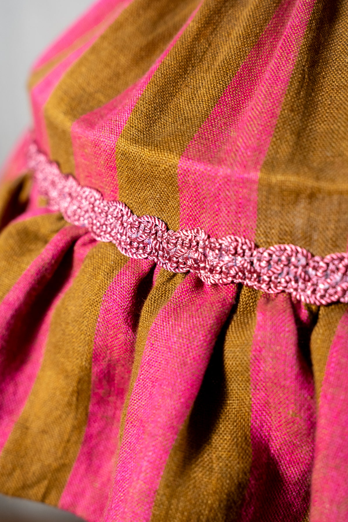 Handmade 12-inch linen carousel shade with raspberry and ochre stripes, vintage trim and pendant fitting. Cosy cottage style.